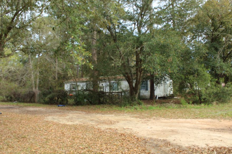 Rezone from mobile home to residential so a new home can be built. Subdivide the land and build a few more homes! Over 1.6 acres of land in a prime location in Navarre FL! 3 beds and 2 bath mobile home built in 1997, double wide with 1440 sq ft! On septic and the owner has never had issues with the septic. Thee is a shed with electricity , a small pole barn to park mowers and trackers in, and plenty of land with over 1.6 acres. The double wide trailer has a metal roof, tie downs, and a deck! The land backs up to the base so there us ultimately privacy! No homes behind the property! The Eglin Reservation is adjacent to the land! If you like wild life, get a hunting licenses and go on the reservation to hunt. You could also just watch beautiful deer come from the reservation. This property so much potential! Build homes, build one big single family detached home with a barn, or just renovate the mobile home and have a huge property close to town! Buyer to verify all dimensions and information. 