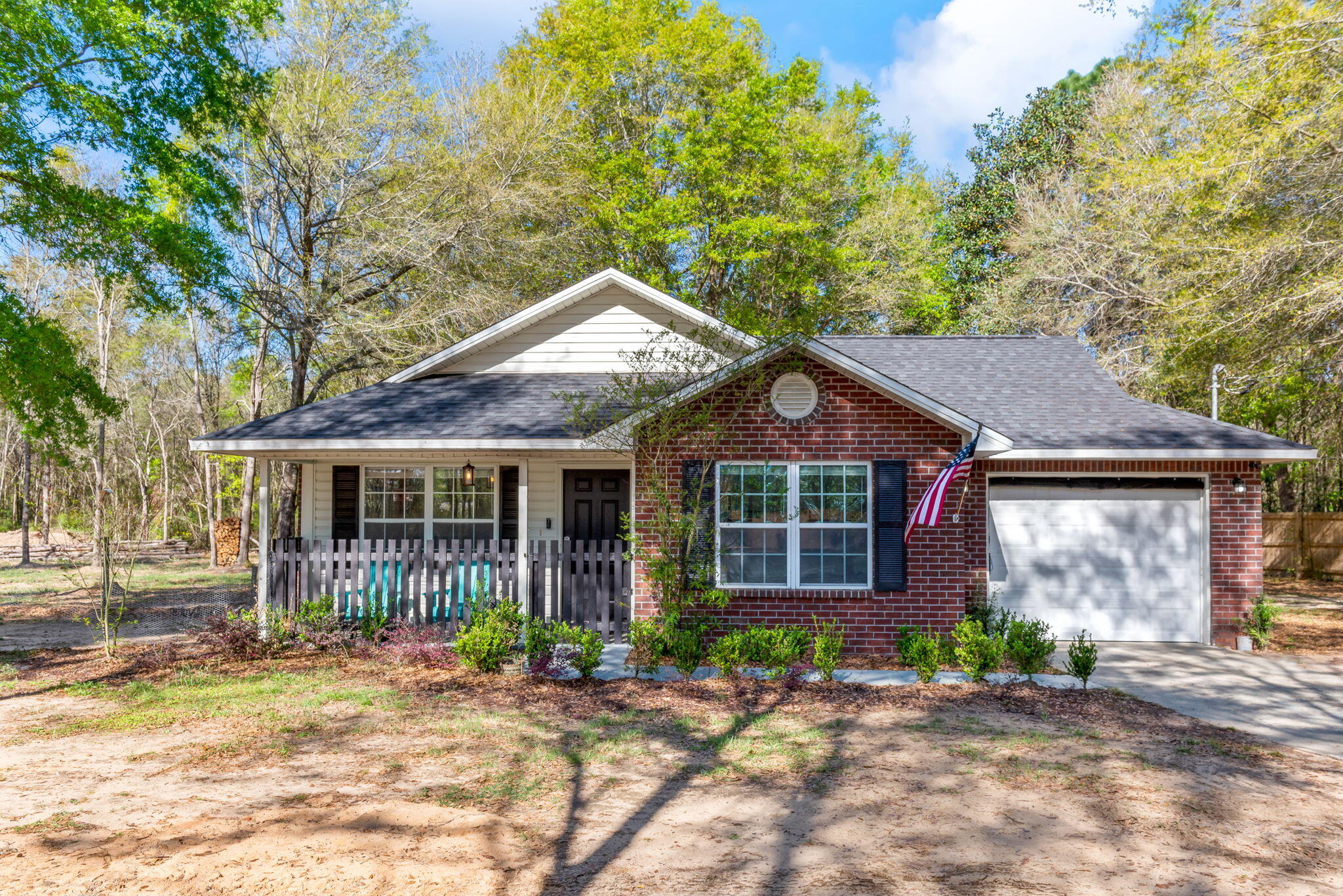 Leave the hustle and bustle of city living behind as you are welcomed to this adorable country cottage, recently upgraded, and tucked away on a large 2.1 acre wooded lot surrounded by mature trees offering an ultimate sanctuary and room to expand. With a long driveway and the home sitting midway on lot, you will find ultimate privacy and a peaceful naturistic setting. This home's lovable attributes entail its picturesque yet inviting curb appeal, framing the generous covered front porch, accented with cute black shutters just waiting for you and a pair of rocking chairs! You are greeted by the fully upgraded interior where you are immediately led into the inviting family room featuring a raised ceiling, updated ceiling fan, large window boasting wonderful