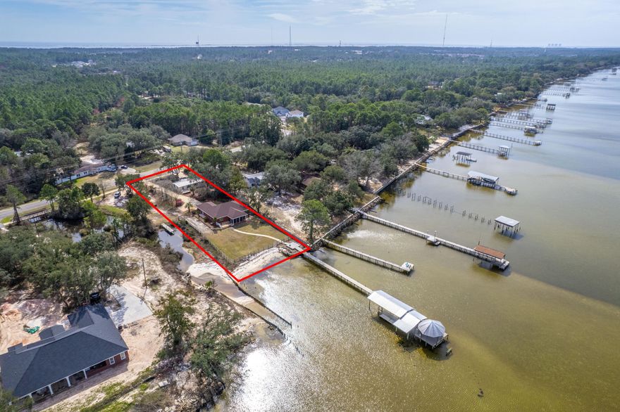 Unique WATERFRONT property offering 2 separate dwellings, making for a spectacular investment opportunity in the form of an airbnb or income-producing potential. The front cottage has an open floor plan with 2 bedrooms and 1 bathroom and is very well maintained. It also features its own driveway and private access. The primary house located on the back of the property has a large open-concept living area with vaulted ceilings, 3 bedrooms, and 2 full bathrooms. The oversized master bathroom boasts a dreamy garden tub as well as a separate tile walk-in shower and two separate vanities. In the back yard, you'll enjoy the screened-in porch with a birds-eye view of the yard and the bay, the white sandy beach area, and the sprawling dock and boat house with boat slip and lift, including