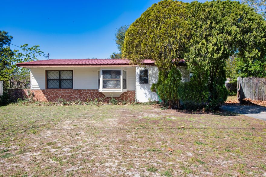 Are you ready for your next flip? This could be it! Centrally located to shopping, beaches, parks, and bases, this home has the potential to be absolutely awesome. This property features solid block construction, a metal roof, newer HVAC and a newer water heater. The dining area has a pantry behind the curtains. The kitchen is small with vintage cabinets and accessories.  There is a larger style full bathroom and a linen closet and attic access in the hallway.  The large screened back porch is great for enjoying Florida weather all year. The utility room is off the kitchen.  Buyer to verify all information. Professional photos coming soon.
