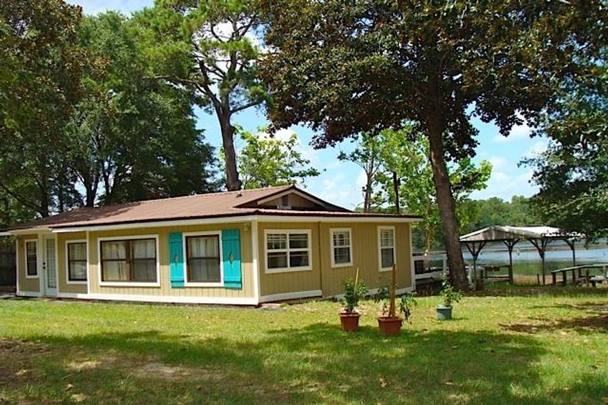 FANTASTIC LAKEFRONT VIEWS FROM THIS COTTAGE -- Just what you are looking for in a waterfront getaway! This 2 BR 2 BA home is perfect if you are looking for activities centered on Lake Juniper. Fish to your heart's content from the dock, or take the boat out on this 630 acre lake full of brim, crappie & bass. The house has recently been updated & repaired and features an open floor plan with breakfast bar, front & back sun porches, and an open deck overlooking the lake. Come take a look and you will fall in love with the lot which features over 200' of waterfront! Juniper is the only State maintained lake in the area, which means no HOA fees, and the State takes care of all maintenance on the dam. All dimensions & sq. footage to be verified by buyer. House is being sold As-IS.