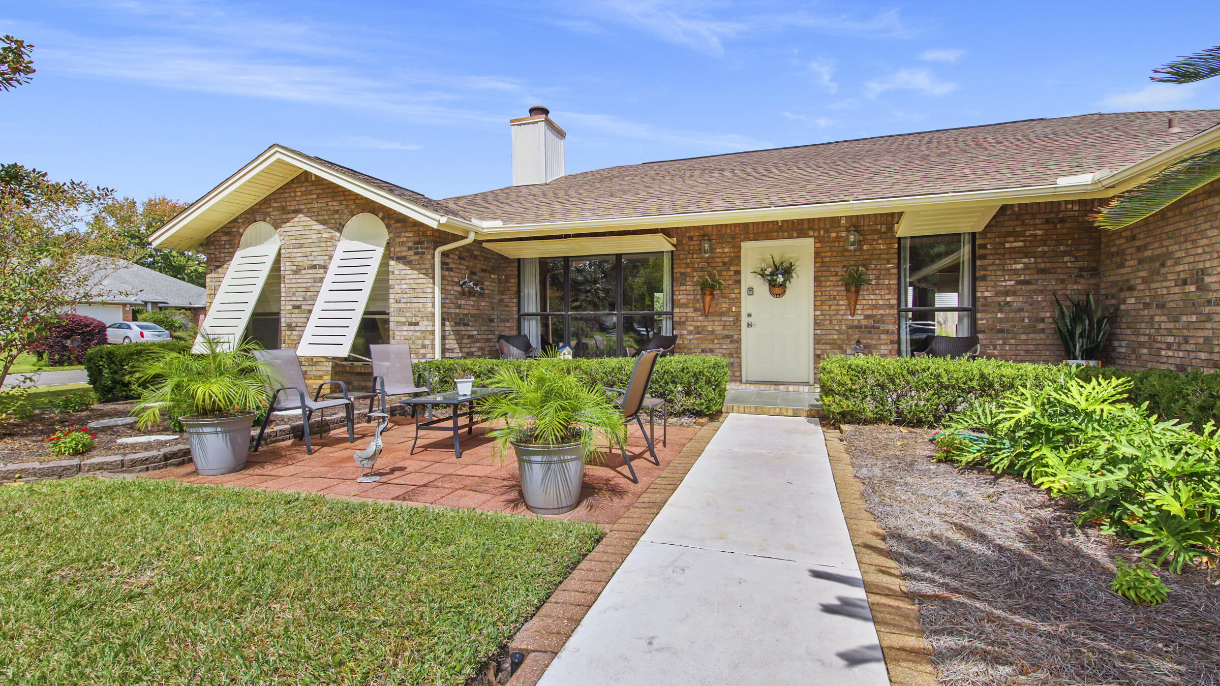 Beautiful home located on corner lot, great curb appeal, in Kell-Aire Gardens in Destin. As you enter this 3 bd 3 full bath home, you will notice the charming open living/dining room area with wood fireplace, vaulted ceilings, large open windows for plenty of natural light. Spacious kitchen with marble counter tops with bar for extra seating. Built in coffee bar. Custom oak cabinets throughout home in kitchen and all bathrooms. Split-bedroom floor plan with spacious bedrooms and the guest bedrooms have bamboo flooring. Large Florida room is heated and cooled for your entertaining pleasure. Great front and back patio seating areas, minutes to beach, Brick exterior with Bahama storm shutters, Parking will accommodate a boat, RV or other activity vehicles. Home sits across from the