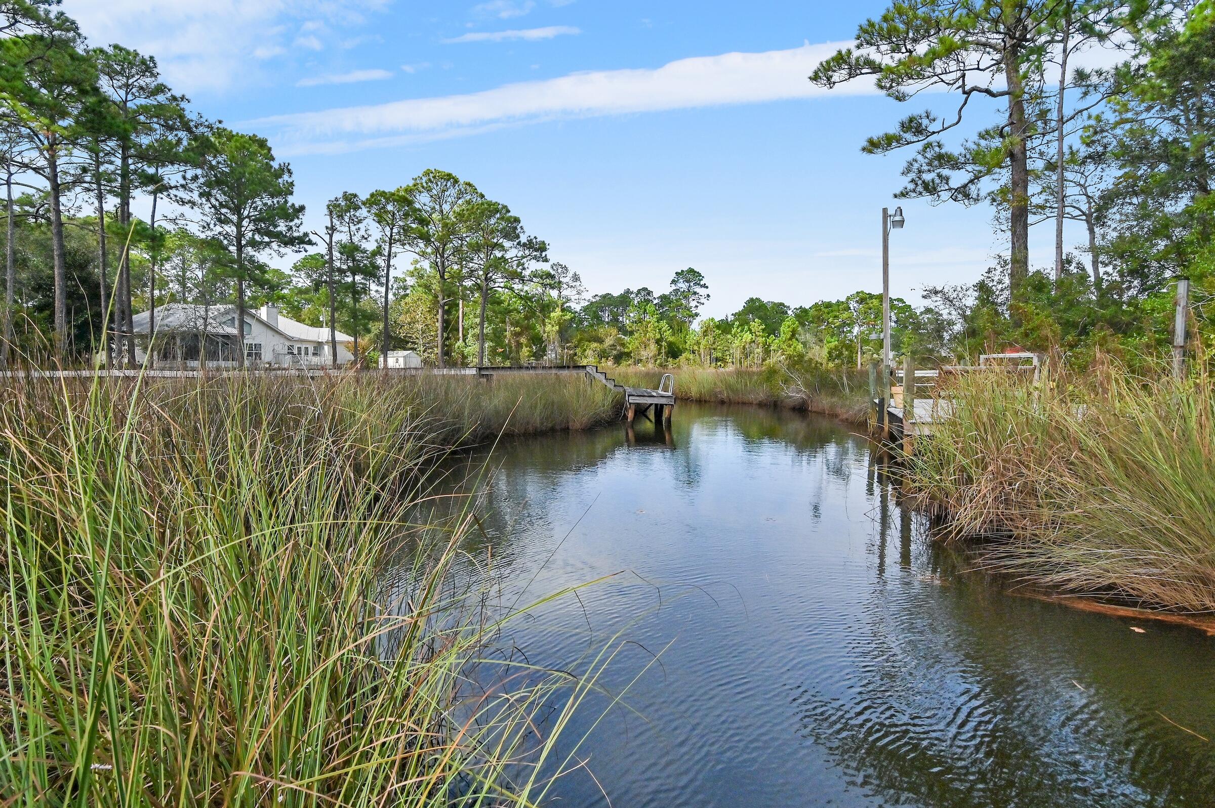 Discover a tranquil, single-level retreat ideal for coastal living. Surrounded by natural beauty, this residence offers direct access to boating, paddleboarding, kayaking, and fishing--perfect for the outdoor enthusiast. Within 10-30 minutes of top-rated schools, parks, dining, shopping, and medical facilities, it balances convenience with relaxation. An open living space, split-bedroom floor plan, screened porch, spacious deck, and boardwalk to the dock create the ultimate indoor-outdoor gathering spot. Canal access to the bay with an estimated 5'+ water depth. New roof to be installed by closing.  You do not want to miss this one!