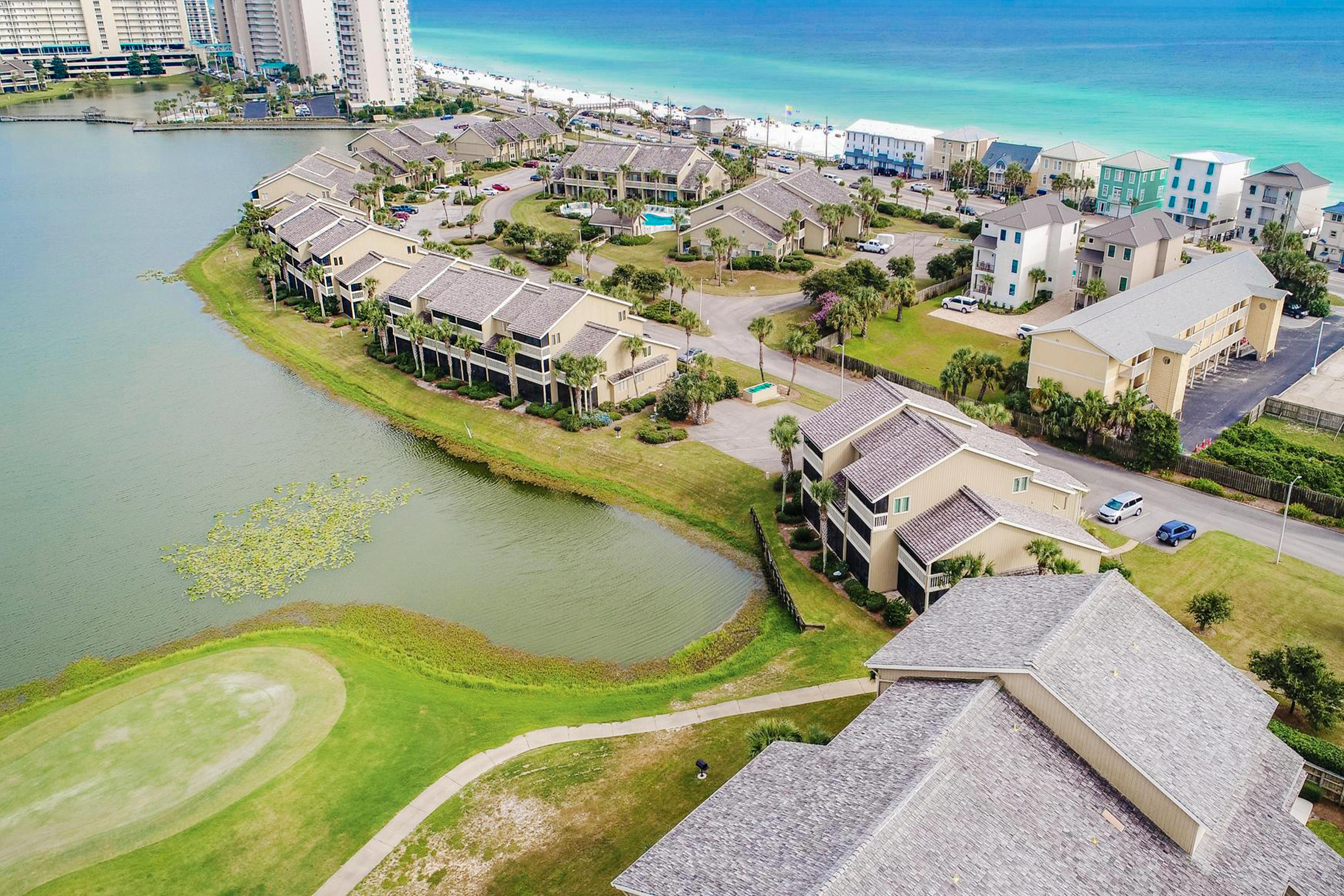 Enjoy this lovely lakefront unit within Seascape Lakefront Villas a prime location just steps from the beach. This unit features two stories with a lakefront master suite, two guest suites, and two balconies overlooking Stewart Lake offering tranquil views and tropical landscaping. The main level is open, spacious, and features direct access to the large screened-in balcony. The upper level master suite features a private screened-in balcony. Sip your coffee while watching the sunrise over the lake a perfect way to start the day. This is an ideal second home, investment property, or even full time residence. 
Seascape is a favorite vacation spot with amenities including: 18-hole golf course, tennis and basketball courts, pools, bike rentals, 2,000 feet of beach frontage. Paradise