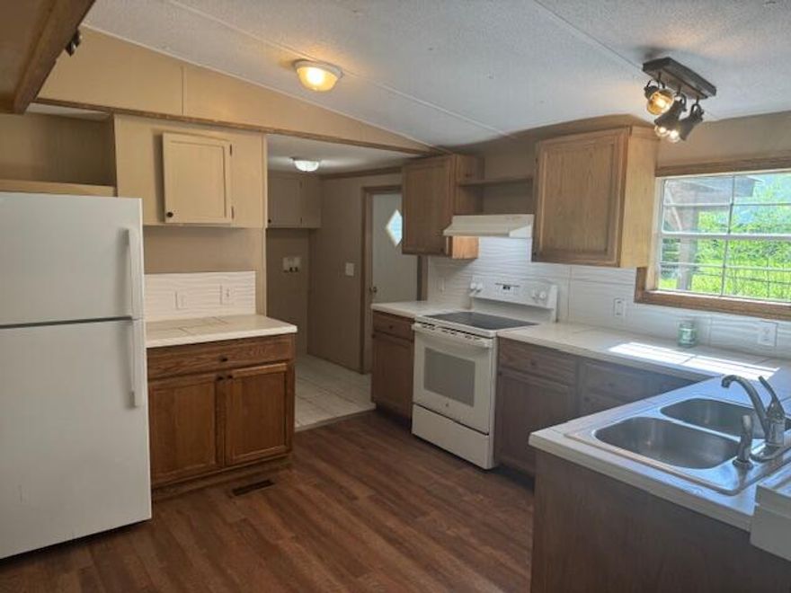 Are you looking for peace and tranquility? This property has it! It is set back from the road and partially surrounded by woods, pleasantly secluded. This fully renovated mobile home provides you with plenty of space for your living needs. Wood-grain vinyl planks throughout the home, with tile in the laundry area and bathrooms. New metal roof 2024 as well as recent HVAC 2024. Kitchen cabinets, countertops, and appliances have also been recently updated. Outside provides you with a two-car carport, a workshop, and a storage shed as well as a newly placed gravel driveway. You can watch the sunrise on your front porch and watch the sunset on your back porch! Chained link fence encloses the .258 acre property. Cash or Conventional only Don't let this one slip pass you! Call for showing today.