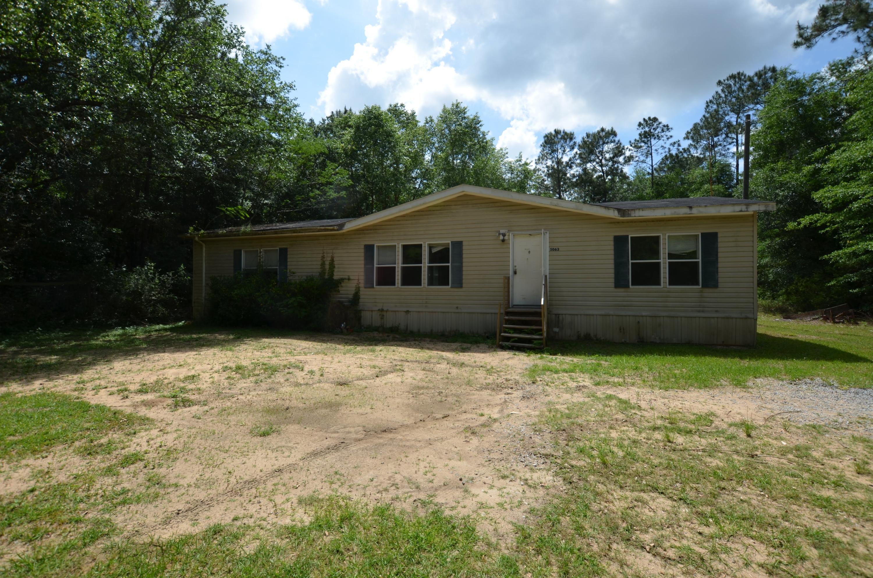 Just a short distance East of Hwy 87 or West of Holt, this 2006 REO Mobile home has country life written all over it! A split bedroom design double wide home, this property has 3 bedrooms, 2 baths, a nicely positioned galley style kitchen which opens to the dining area, living room and laundry. All flooring is laminate and exterior is mostly wooded, except closer to the home for extra privacy. Call today to set up your showing! Sellers asking price is $56450