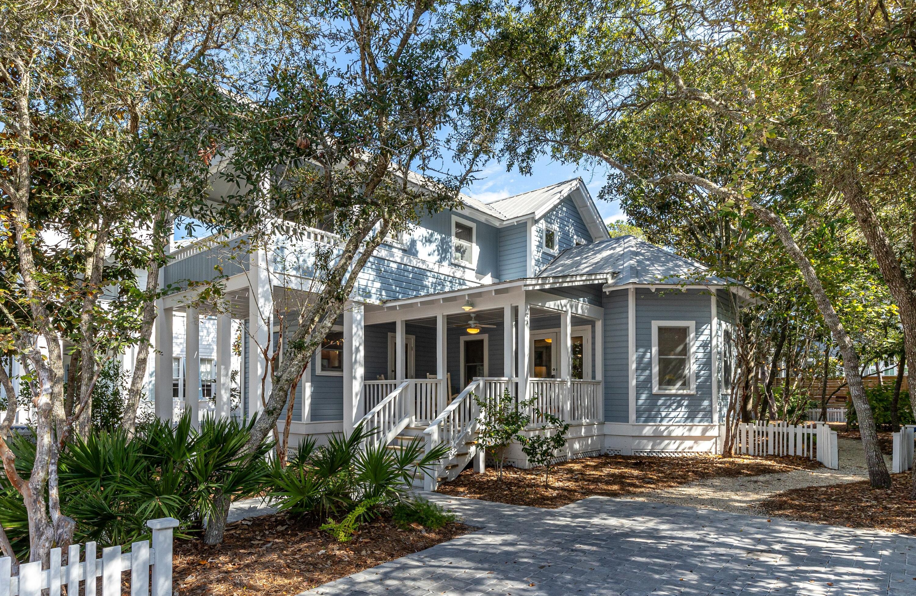 Blue Skies is a traditional Seaside beach cottage that will bring back favorite memories of your family's summer vacations.  Situated on a beautiful oversized lot, this property offers great potential for future expansion of the existing cottage and even an additional guest cottage. French doors from the front porch welcome you into the living area with a sense of grand spaciousness provided by a vaulted ceiling. Natural finished pine floors are found throughout the cottage. Built-in bookcases with cabinets below provide a wonderful display for your family photos. The galley kitchen includes a copious amount of upper and lower cabinets for storage. The kitchen has been updated with quartz countertops, tile back splash and stainless-steel appliances. The dining area includes a buffet area to host family dinners. Another set of French doors off the living area leads to a screened back porch for relaxing at the end of the day. The expansive back yard is shaded with mature oaks and magnolia trees and is the perfect setting for outdoor entertaining. A guest bedroom with queen bed and full bath are located on the first level. On the second level is the primary suite with king bed and a private porch.  The en suite primary bath has a double vanity, quartz countertops, white tile shower surround and tiled floors. Also on the second level is the laundry area, along with a third bedroom with two sets of bunk beds and its own full bath.  All three baths have been completely updated within the last twelve months.  Children will scurry back from the beach to be the first to wash the sand from their bathing suits in the outside shower. Private paved onsite parking.