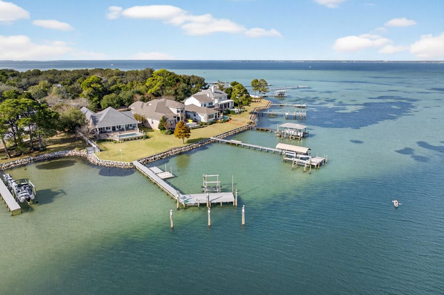 901 Peacock's Point Drive offers a rare single-level waterfront residence positioned at the mouth of Joe's Bayou with direct access to the Choctawhatchee Bay. The home spans approximately 2,776 square feet with four bedrooms and two and a half baths arranged in a practical split floor plan that maximizes privacy and natural light throughout.The entry flows into an open living area with a wall of windows that frames the water and brings in consistent bay views. Reclaimed wood flooring sourced from an 1890s Chicago train station adds character without overwhelming the clean coastal aesthetic. The kitchen, dining, and living spaces connect easily, creating a central gathering area suited for both everyday living and entertaining. The primary suite sits in its own wing with... unobstructed water views, a spacious bath, and direct access to the outdoor living area. The additional bedrooms are positioned on the opposite side of the home along a private hallway and share a full bath.

Outdoor spaces are designed for functional waterfront living. A covered porch extends the main living area and overlooks the saltwater pool and bay. The property includes a deep water boat slip, an additional slip with lift, and quick access to Destin Harbor and the Gulf. The three car garage provides ample storage for vehicles and coastal gear.

Impact resistant windows, spray foam insulation, a whole-home generator, and other thoughtful construction updates contribute to the home's comfort and efficiency. 901 Peacock's Point Drive offers a refined single level layout on a protected deep water location in one of Destin's most desirable bayside enclaves.