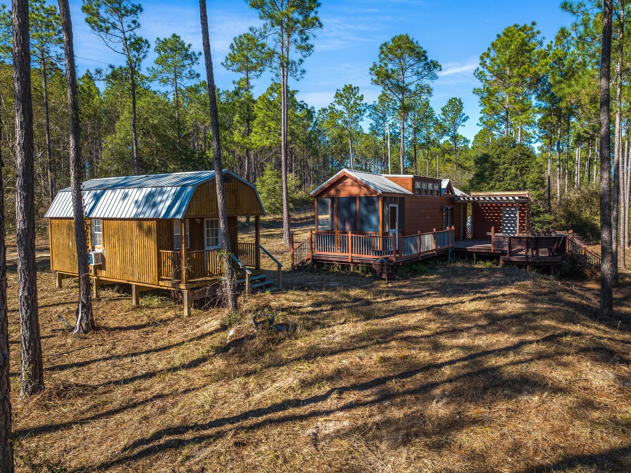 Welcome to Walton Plantation, the outdoorsman's paradise! Come see this beautiful property that comes with a variety of amenities for both relaxation and recreation.The main cabin is a well-equipped and comfortable living space featuring a layout that includes a bedroom, an upstairs loft, and a full bathroom with a shower, tub, and tankless water heater. The cabin also has a stacked washer and dryer and a full kitchen, as well as an HVAC system for climate control. The ''Little Lodges Cabin'' was installed in 2014 and features a spacious deck with bench seating and a screened back patio. The kitchen is equipped with a gas stove that is powered by an on-site propane tank, as well as a microwave. The living room has an electric fireplace for added warmth and ambiance. The property has a de