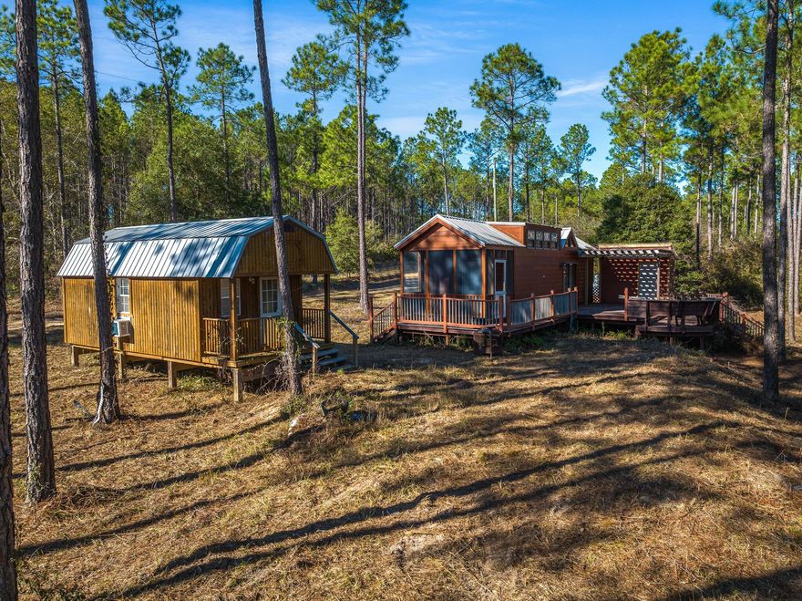 Welcome to Walton Plantation, the outdoorsman's paradise! Come see this beautiful property that comes with a variety of amenities for both relaxation and recreation.The main cabin is a well-equipped and comfortable living space featuring a layout that includes a bedroom, an upstairs loft, and a full bathroom with a shower, tub, and tankless water heater. The cabin also has a stacked washer and dryer and a full kitchen, as well as an HVAC system for climate control. The ''Little Lodges Cabin'' was installed in 2014 and features a spacious deck with bench seating and a screened back patio. The kitchen is equipped with a gas stove that is powered by an on-site propane tank, as well as a microwave. The living room has an electric fireplace for added warmth and ambiance. The property has a de well for a water supply and also has a backup generator. It also has a septic tank for wastewater management.

The small cabin is a cozy and efficient living space with studio layout, including two overhead lofts for added sleeping or storage space. The cabin was built in 2017 and has a front porch for outdoor relaxation. It is equipped with a half bath and is climate controlled by a wall unit. The small cabin is a great option for guests or as a secondary living space on the property.

The pole barn and pirate ship play structure on the property provide additional outdoor spaces for relaxation and recreation. The pole barn is a spacious structure built in 2016 and includes a ceiling fan, lighting/power, and picnic tables, making it a great place for outdoor gatherings. It also has a one-car garage/storage space with a roll-up door for added convenience. The pirate ship play structure was built in 2015 and is a fun, imaginative play space for kids. It has two slides, a crow's nest, masts, a wooden steering wheel, a figurehead, and a porch swing. The pirate ship play structure is a great place for kids to use their creativity and have fun, and it is complemented by a kids' swing set/play set. 

Walton Plantation is a privately held North Walton County gated community for outdoor and hunting enthusiasts.  Included in this expansive sportsman plantation is the use of 2500 acres of Walton Plantation land for recreational use.  Residents have access to a rustic outdoor chapel, public restrooms, ponds for fishing, a community garden, ATV riding trails, equestrian trails, and a hunting club for an added annual fee of $360 that allows for hunting on approximately 2000 additional acres within the community.  The dirt roads are privately and professionally maintained by the HOA.