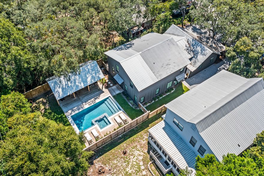 Welcome to 375 DeFuniak Street, offering the best of Grayton Beach. Just steps from the beach and popular dining options, and sheltered behind massive live oaks, sits an original 1953 Grayton Beach Cottage that has been expertly remodeled and expanded, preserving its Old Florida charm with modern luxury finishes. Upon entering this 6 bedroom, 4.5 bath home, you are greeted by 15-foot vaulted ceilings defining a large open kitchen on one end and a comfortable great room on the other end. The kitchen is outfitted with top-of-the-line appliances, including a six-burner Wolf Range, custom cypress cabinets, an under-counter ice maker, and a dramatic oversized range hood. The large kitchen island has ample seating for 6, and a side pantry nook houses small kitchen appliances and dry goods.

Across from the kitchen, the great room is anchored by a custom gas fireplace and is outfitted with comfortable furniture that invites relaxation.

The remainder of the downstairs features a charming dining nook, a large laundry/mud room with extensive storage and an additional full-size refrigerator, a powder bath, and 2 king master suites, each with their own bathroom.

Upstairs, 3 queen bedrooms and a bunk room share 2 generously size bathrooms and an upstairs laundry room.

Now let's talk about the back yard! The generously-sized fenced backyard highlights a substantial resort-style heated saltwater pool with hot tub. The custom outdoor pool pavilion was built with vaulted ceilings to shelter comfortable seating and dining areas, as well as a gas grill, making outdoor living a delight.

Throughout the home you will find handmade Moroccan Zellige tile, reclaimed oak floors, and custom lighting and accents. The doors and windows have all been replaced and upgraded to meet current Hurricane standards. There is a side storage room to house all your beach equipment and bicycles, and the front of the house has ample parking for 7 vehicles. Come take a look and see what the best of Grayton has to offer.