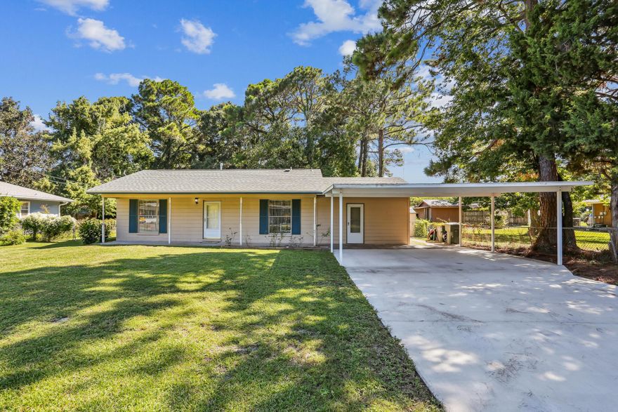 Price Reduced! This affordable home is centrally located between Hurlburt & Eglin Air Force Base and has a new roof and the water heater that was replaced in 2023. Home warranty provided ($650 value) for peace of mind! Eat-in kitchen has tiled floors & stainless-steel appliances: dishwasher, smooth-top stove and microwave. Kitchen has a deep stainless-steel sink with nickel pull-out faucet. There is plenty of countertop space & cabinets including a side cabinet that can be used as a coffee bar. Newer wood look floors throughout. Spacious living room with ceiling fan. The enclosed garage space that would be an excellent den or 4th bedroom addition has new carpet. Remodeled bathroom with tub/shower with tiled backsplash & border Dressing vanity with tiled countertop. Pedestal sink with nickel faucet. Outside the long driveway has been expanded to 20' wide and covered parking was added for two cars with plenty of parking for your guests. Up to 6 vehicles can easily park. Room for RV or boat! This property is almost 1/4-acre with a completely fenced backyard with an open patio. There are two storage buildings for extra storage! This adorable home is being sold "As Is". Don't miss out on this home! See the RE-ENVISIONED photos to imagine your upgrades! Call for your appointment today!!!  