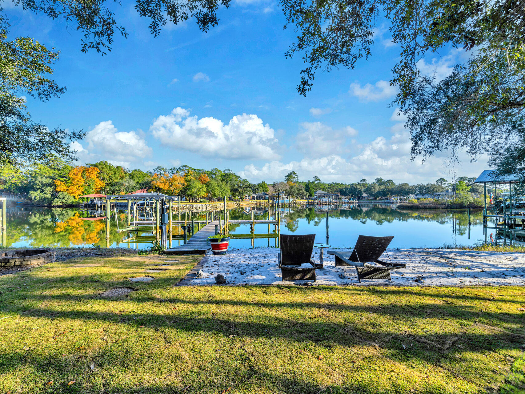 Waterfront dreams do come true in this gorgeous ''Southern Plantation'' style home with 100' on beautiful Shirks Bayou in south Niceville. The .71-acre lot is studded with majestic oaks and offers a private beach area along the water, a firepit area and a pergola covered paver patio area. The ''T'' shaped dock is extra wide and can accommodate large boats offering multiple deep water boat slips as well as a boat lift. A charming covered front porch greets you and your guests the ''southern way''. Entering this home through the wide foyer, you will find the formal dining room on the right that flows into the large living room accented by a built-in entertainment center, gas fireplace and wonderful views of the bayou. The gourmet kitchen features stainless steel appliances, lots of cabinets and counter space and a large breakfast bar. Open to the kitchen is the light and bright breakfast room that also offers views of the private back yard and bayou. Just off of this room is a HUGE media/game room overlooking the bayou that features a kitchenette making it the perfect place for large family gatherings. The expansive master suite with two huge closets is located downstairs along with a 2nd bedroom with a wall of custom cabinets that also has access to a full bath. Upstairs you will find two enormous bedrooms that share a Jack-n-Jill style bathroom. There is plenty of parking space in the THREE car garage because there is also a heated and cooled storage/workshop area attached to it. Want to park your RV on your property? No problem, there is plenty of space for that as well! Additional noteworthy features include 2022 roof, 2013 water heater, 3 HVAC units, 2024 renovated downstairs bath, 2023 lawn pump, 11' ceilings and new paint throughout. This is the waterfront home you have been waiting for!! 