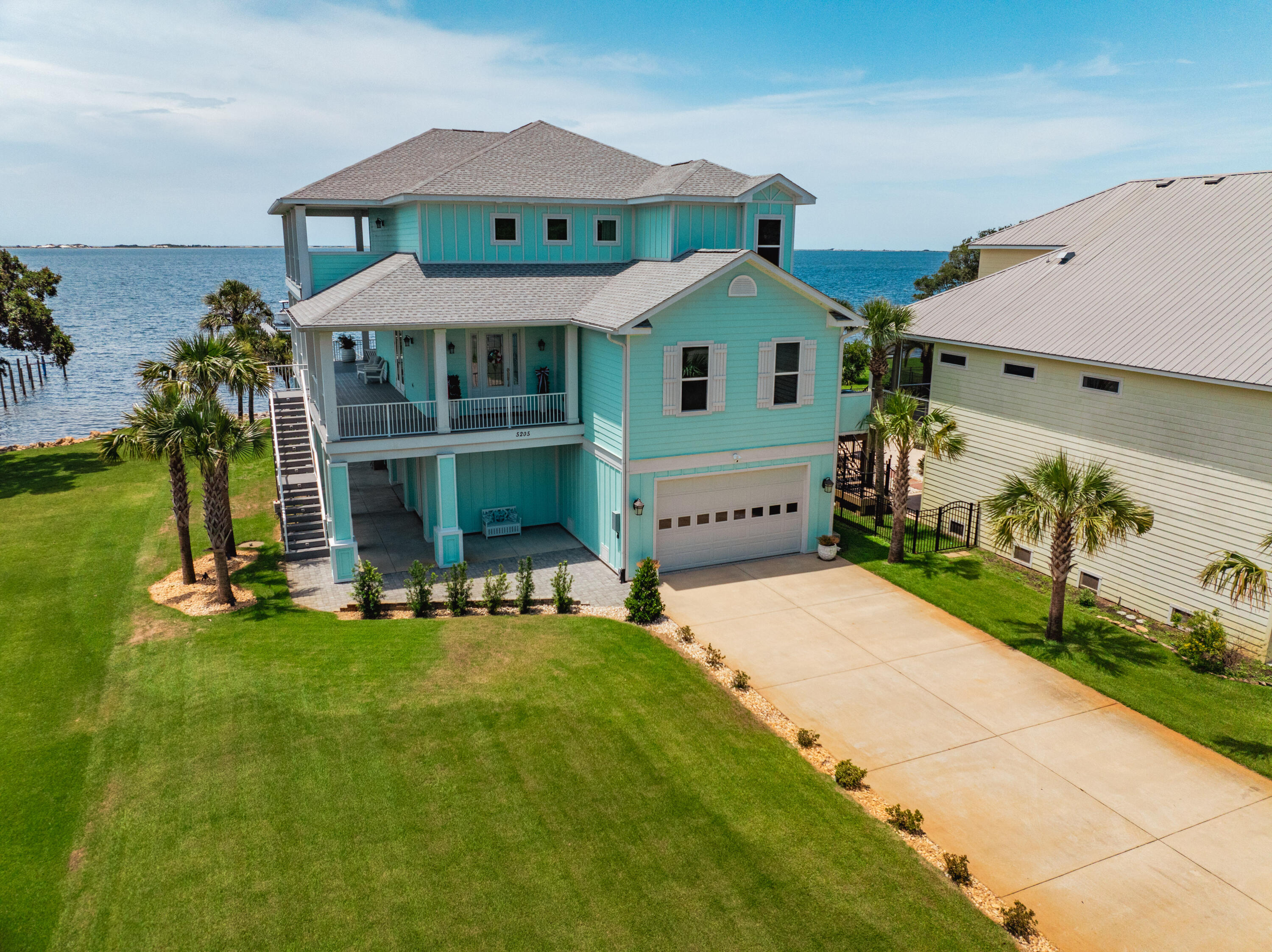Welcome to this bright and sunny custom-built waterfront home, offering breathtaking panoramic views of the Santa Rosa Sound. Designed to maximize the beauty of its surroundings, this home features a main living area and kitchen with a wall of high-quality impact glass doors, ensuring stunning water views from every angle. The open kitchen is a chef's dream, featuring custom white cabinets that extend to the ceiling, an oversized walk-in pantry, and top-of-the-line stainless steel finish appliances, including a stainless oven, microwave, dishwasher, and a 36' gas range and refrigerator , large island with storage, vented range hood, under-cabinet lighting, recessed lights, and pendant lights complete this gourmet space. The countertops are adorned