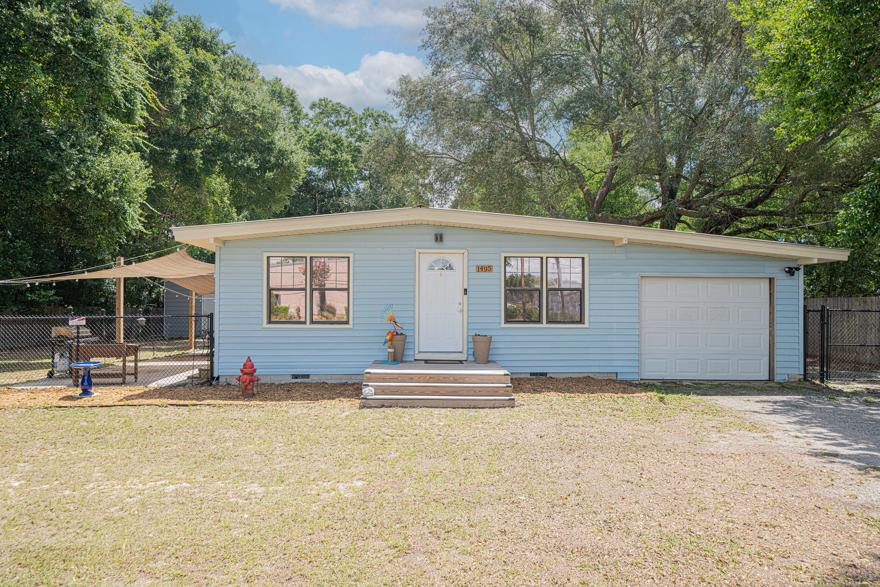 Welcome to 1495 Hickory Street, a charming 3-bedroom, 1-bath cottage nestled on a spacious 0.41-acre lot, just one block from the Mid-Bay Bridge Connector in Bluewater Bay.Built in 1963, this sweet home boasts new LVP flooring, fresh paint, an updated bathroom vanity, and vaulted ceilings that create a light, bright, and open living space. The cozy living room seamlessly flows into an open dining area and kitchen. New sliding glass doors lead to the side yard and patio, perfect for relaxing or entertaining.The outdoor space truly sets this property apart. Enjoy unwinding under the sunshades, magical evenings under the cafe lights, or stargazing by the fire pit. You'll have plenty of room to spread out with a 35x24 metal garage (featuring power and three garage doors), a 24x24 pole barn, a powered shed, and an additional storage shed. The carport adds even more functionality with a laundry room and a garage door for added privacy.
Additional highlights include:
* New chain-link front fence and wooden gate at the back
* New front and side porches/stairs
* No HOA
* Metal Roof (2008)
Whether you're a first-time buyer, looking to downsize, or seeking a smart investment, this charming, move-in-ready gem with immense potential is a must-see!
* Water Heater 2008 *HVAC 2009