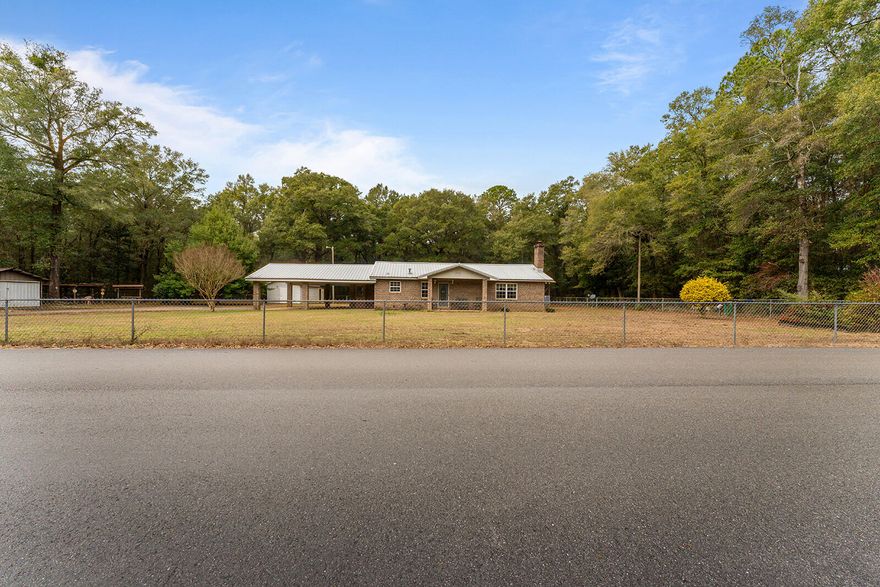 Opportunities like this don't come along often. Set on a spacious 2-acre residential parcel in Holt, Florida, this 1983 brick ranch home offers privacy, flexibility, and room to grow. The home features 2 bedrooms and 2 bathrooms with a flex room, separate kitchen and living room (with a full wall fireplace) and all of that with solid, classic brick construction that provides an excellent foundation for comfortable living or future updates.Surrounding the home is a chain-link fenced yard with an electronic gate, offering added security and peace of mind. Within the fenced area, you'll find three outbuildings, perfect for storage, workshops, hobbies, or equipment -- a rare and valuable feature for those needing extra space. Beyond the fenced homesite, the remaining acreage is unfenced and uncleared, giving you the freedom to shape the land to your needs whether for recreation, expansion, or maintaining natural privacy. This combination of usable cleared space and untouched land creates endless possibilities for outdoor living, gardening, or future improvements.

Enjoy the quiet of country living without the constraints of a subdivision, all while remaining within reasonable distance to local amenities. Whether you're searching for a primary residence, a rural retreat, or an investment opportunity with land value, this property delivers space, security, and potential.

Bring your vision and make this Holt property your own ... where privacy meets possibility.

Outbuilding Rough Dimensions
16 x 18 Metal Storage Outbuilding with Concrete Floor
14 x 16 Outbuilding with 14 x 9 attached enclosed shed
12 x 18 Shed
17.5 x 16 Shed with lean - to attached

Well pump for irrigation and irrigation system sold in AS IS condition.
All informed to be verified by the Buyer