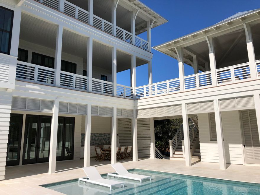 This striking home built by Coastal Elements construction showcases unparalleled outdoor living areas, beautiful interiors and privacy only found in Bannerman Beach Estates. As you drive through the gates into Bannerman Beach Estates, you instantly feel hidden from the rest of 30A. Guests are welcomed into the first floor by a large entertaining room complete with a wet bar area showcasing beautiful tile work from Q-Tile. Two guests suites and a third multiuse room complete the interior of the ground floor along with an additional full bathroom and large laundry room. Outside you find an expansive pool deck with a large infinity edge pool, summer kitchen, lounge area and sitting area circling a gas fire bowl.