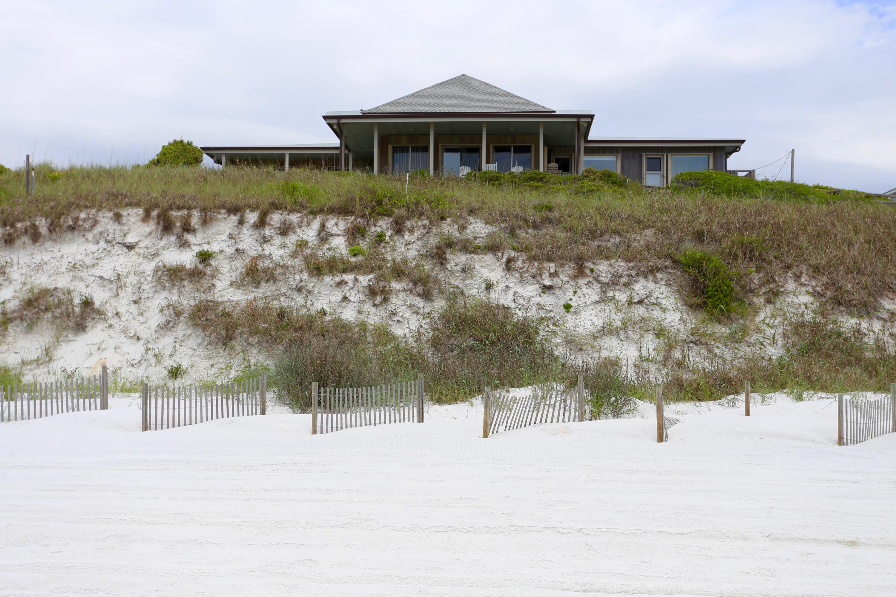 This incredible location cannot be beat! Gulf front home in Dune Allen, newly refurbished and sitting on a double lot totaling 150 feet of beautiful water front property. Just walk down your private walkover access and sink your toes in the sand. The home is one story with an open floor plan and cathedral ceilings. Features 3 Bedrooms, and each provide access to the outstanding wrap around porch and patio overlooking the gulf.Home is at approximately 35 feet in elevation, and the lot has a double ShoreGuard industrial vinyl sheet pile bulkhead built in 2006. Also boasts a large attached garage and detached work shed.