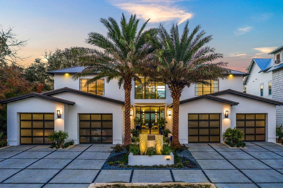 Striking contemporary architectural details juxtaposed finely appointed finishes and masterful insulated concrete construction define this rare compound property newly built in 2020 by Jeremy Trantina primely located in the heart of Seagrove Beach. The outstanding exterior facade is beautifully designed with ample symmetry featuring a four car garage with iconic glass doors flanking the tranquil entryway featuring custom designed steel windows and entry doors that characterize this modern marvel. The two story vertical footprint offers an extremely open living concept with a sprawling layout catering to entertaining guests as well as thoughtful seclusion for each bedroom suite which all feature their own bathroom as well as a private master wing on the first level for optimal comfort.