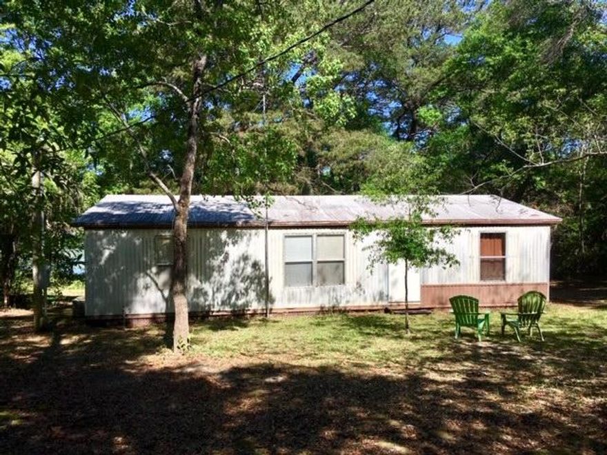 ONE ACRE OF WATERFONT ON LAKE JUNIPER! Come fish till your heart's content on this beautiful wooded property with 2 LOTS and 220 feet of waterfront on Lake Juniper. There is a 3BR-2BA older mobile home on the property with a large screened porch overlooking the dock and the cove that has full access by boat to the main part of Lake Juniper. You'll catch plenty of Brim, Crappie, Shell Cracker and Bass on this 650 acre state-maintained lake. There are no homeowner's association fees on this lake and the State of Florida maintains the dam & shoreline for full peace of mind. The lot is huge and private. The older mobile home is very livable, but is being sold As-Is. All dimensions, acreage & square footage are approximate and subject to verification by the Buyer at Buyer Expense.