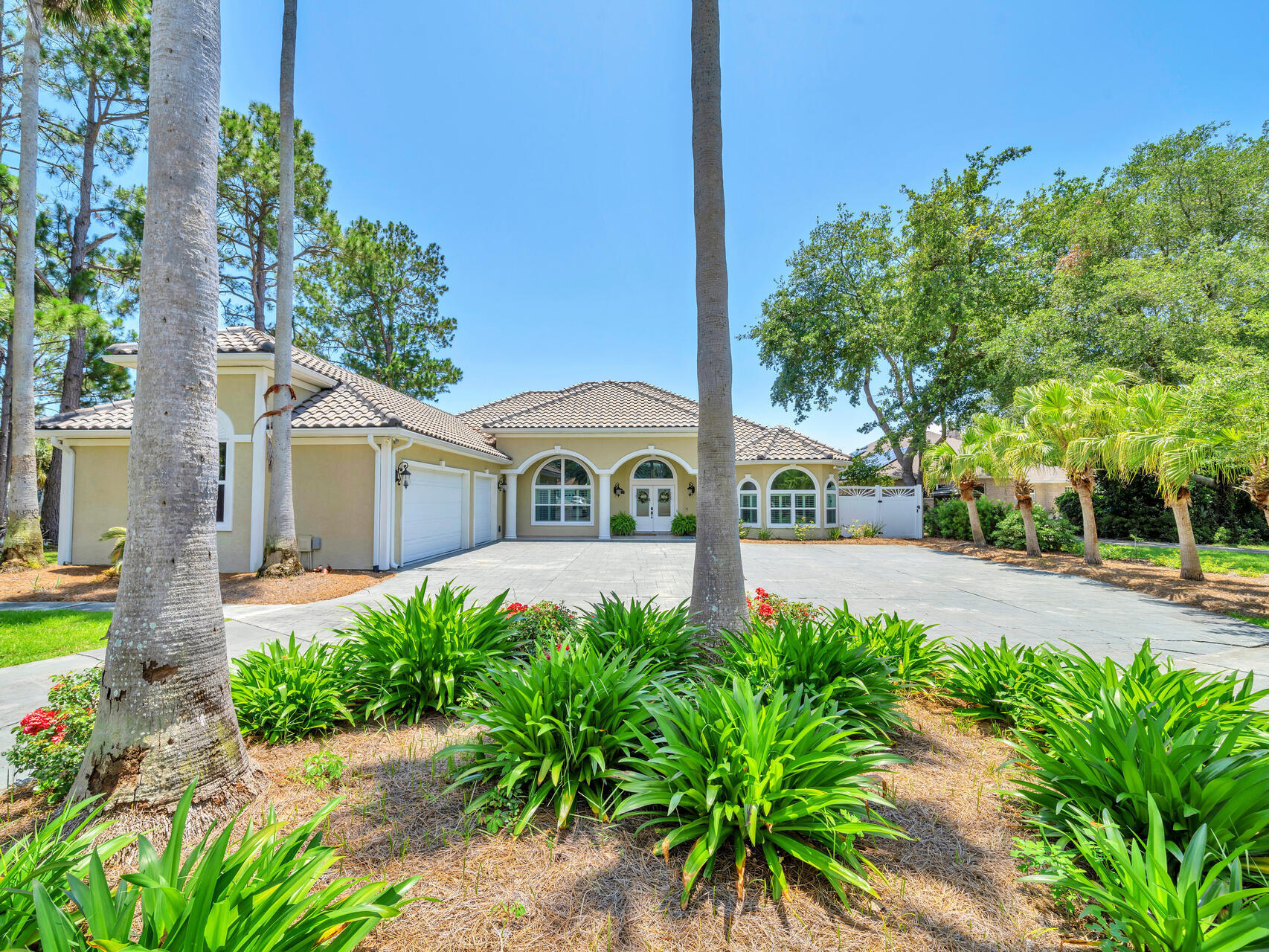 ATTENTION BOATERS! GORGEOUS WATERFRONT ESTATE 5 MINUTES TO THE BEACH or GULF! With almost an acre of land, this property is the epitome of coastal living! This gorgeous one story pool home, designed with an open layout, consists of 3636sf, 4 beds/3.5 baths, oversized 3 car garage, and premium outdoor living with pool, spa, outdoor kitchen, boat dock, boat house, and a spectacular view of the deep blue waters of Grand Lagoon! As you drive through the columns and up the 500' circle drive lined with lush, tropical palm trees, you will begin to appreciate this beautiful home! Upon entering, you will love the spacious feel, accentuated by the 10ft - 12ft ceilings showcased in the formal living and dining areas, which are situated in the center of the home and perfect for entertaining! The dining area invites even the largest of dining sets, as well as a formal seating area with large double doors that open up to the covered patio and pool area.
As you continue through this custom home, you will appreciate the dream kitchen with its optimal amount of cabinet space, island with a second kitchen sink, breakfast bar to seat 4-5, and darling breakfast nook tucked inside a bay window that overlooks the pool area. Recent upgrades to the kitchen include new quartz kitchen countertops, new sinks & faucets and all new stainless appliances, including a double oven & wine refrigerator! The kitchen's full breakfast bar was designed to tie into the adjoining informal living space with gas fireplace, cozy reading nook with window seat with special lighting. The living areas are located in the center of the home, with two full bedrooms and bathrooms located on one side, and the master suite and 4th bedroom/office located on the the opposite side of the home. It is the ideal layout. The enormous master suite boasts it's own marble fireplace, 2 separate sitting areas, with plenty of room for extra large furniture, 2 walk in closets, and a renovated master bath with walk in shower and separate whirlpool tub.
As you proceed through one of the 3 separate sets of French doors, you will fall in love with this backyard oasis! There is more than enough space to accommodate everything from making memories with your family to entertaining even the largest group of guests! Whether you are cooking for the kids, or hiring a catering company for parties, the summer kitchen is the perfect place for preparation. It has everything you need - refrigerator, sink, gas stovetop, and full bar to the outside. There is an automated enclosure to roll down when the kitchen is not in use, or for inclement weather. Another ingredient creating the perfect outdoor experience for all occasions, is he heated pool & spa. Its customized lighting adds the perfect ambiance to your evenings by the pool.
Just beyond the pool & patios is the ideal amount of green space, all sitting on almost an acre of land, beautifully landscaped with a large custom shed and 90' of waterfront along a 1000' wide, beautiful stretch of Grand Lagoon. Stroll down your private dock and enjoy all that living on the water has to offer! Park your boat right in your own back yard, and get ready to enjoy fishing, boating, and all your favorite water activities like never before!
The list of upgrades and extras goes on and on - hookups to accommodate any size RV, a custom shed, new tile roof, new storm windows & doors, renovated baths, Rinnai tankless water heater, plantation shutters, wireless home security system, whole lawn irrigation system with well, and no HOA. That means you have options you won't find in restricted subdivisions, from raising chickens for fresh eggs, to boat and RV parking, to adding an additional structure. It's time to make this one of a kind property your own perfect paradise!
All information is approximate and should be verified by buyer.