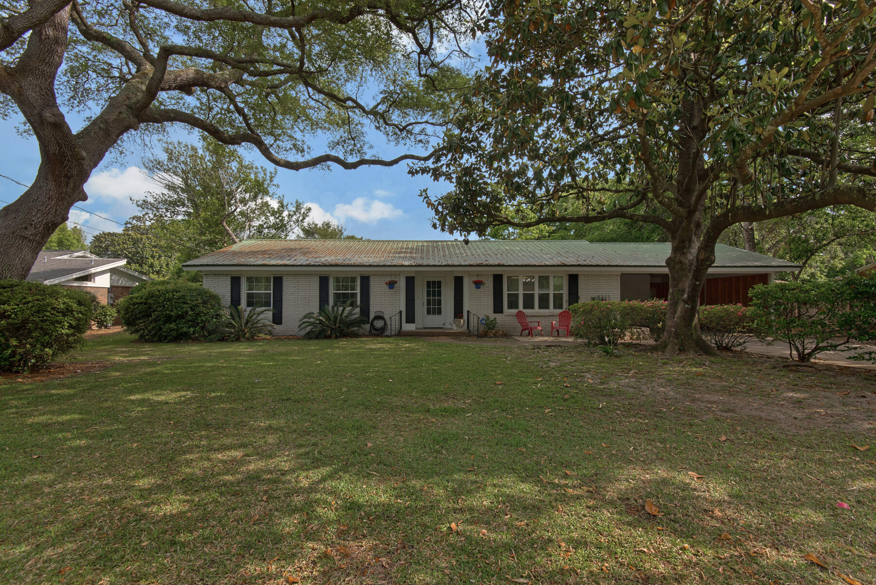 Beautiful private lot. Truly feels welcoming with crown molding, newer kitchen and updated bathroom. Solid concrete construction and 2003 metal roof makes for the perfect Florida home. Floors are original hardwood with tile in the kitchen and bathrooms. Main bath has an amazing jetted tub. 6 panel doors throughout the interior of the house, windows replaced in 2014. Kitchen and appliances: all stainless with flat surface stove, granite counters and overhead microwave. Open kitchen leading to a dining area that's big enough to be used as a dining and family room. Living room also has extra area for large seating. Backyard is an oasis containing a large patio with a covered bar, including a mounted TV and a fire pit to enjoy. Water heater 2015.