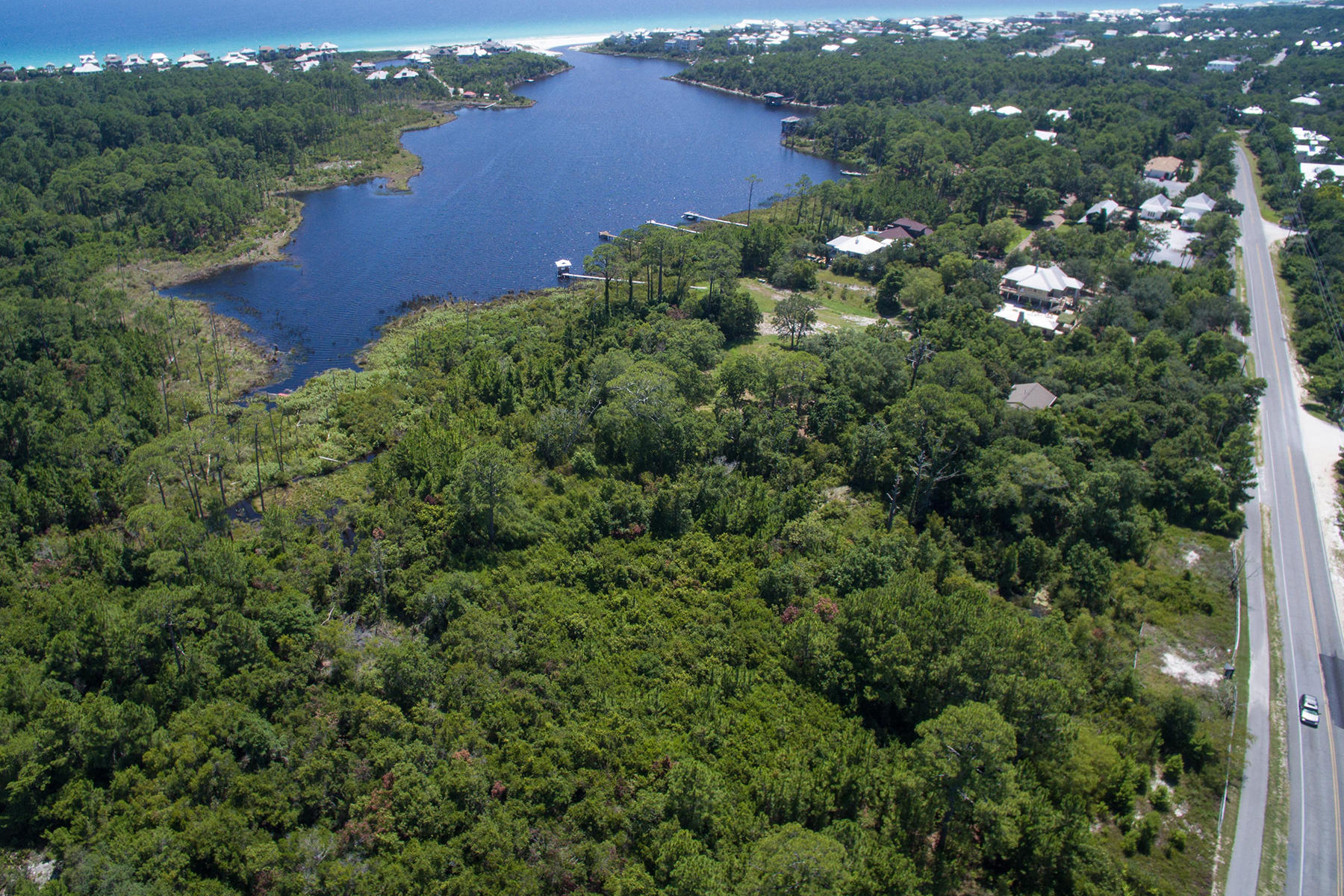 One row back from Draper Lake on the south side of Scenic Highway 30A in Blue Mountain Beach, Florida, this lot slopes down towards the lake so that views of the lake and Gulf of Mexico beyond are available. The seller of this lot has for sale two adjacent lots which can be purchased separately or in addition to this lot. Much of the lot, which is zoned as Residential Preservation, consists of a conservation easement from the Department of Environmental Protection. A retaining wall is in place on each, beautifully treed lot. Drawings of how homes could be constructed on these lots are available upon request.