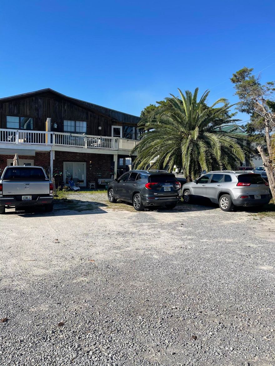 INVESTORS!  2100 ft from the beach! LOCATION LOCATION! This is a unique income property! It is one half of a quadplex with 2 separate apartments!  Upstairs is 2 bedrooms, 2 bath with a huge screen porch & deck. You can see the gulf from the upper deck! Downstairs is a 1 bedroom apartment with patio area and storage. This can mirror the upstairs and a bedroom may be added for it to be two bedrooms. Each half of the quadplex, with 2 units, is separately deeded.  Currently the upper unit is owner occupied & the downstairs is a long term rental.  Even as a long term rental this place is a gem. Walking distance to the beach makes it a PERFECT vacation rental as well! There is unbelievable potential in these two units!  This building is just a short walk to the beach near Pompano Joes.