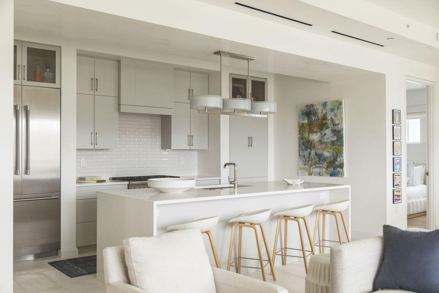 Located in the heart of Alys Beach, this beautifully presented condo was completed in 2021. Exuding a cool, relaxed vibe, it's a superior vacation home or full-time residence for discerning owners. The distinctive open living room flows seamlessly onto the balcony thanks to fully retracting glass doors. Enjoy fresh gulf breezes and abundant natural light in the sitting room as you relax on comfy sofas beneath the high tray ceilings. The private outdoor porch is equally well designed, with ample space for an outdoor loveseat, deep cushioned armchairs and a dining table. The predominantly white kitchen combines high-end stainless steel appliances, cool quartz countertops and a white tile backsplash. The contemporary breakfast bar is a sleek expanse with stools lined up for happy hour drinks and snacks. The adjoining dining area provides the perfect formal dining and entertaining setting beneath the designer lighting fixture.  After a busy day, sleep dreamlessly in the master bedroom and awaken to beautiful views through the floor-to-ceiling windows. An accent wall adds a touch of interest to this sophisticated space. The sleek ensuite has a luxurious twin vanity and a generous walk-in shower. Two additional bedrooms, both with private bathrooms, provide spacious quarters for overnight guests. The stunning Caliza pool, tennis courts, and a state-of-the-art fitness center deliver an enviable lifestyle at The Camden, along with deeded beach access and assigned parking. Stroll down to the beach for a morning walk with gliding pelicans before relaxing at the beach club. Nearby, delightful Alys Beach offers upscale dining, chic cafes, and boutique shopping with a suitably refined coastal ambiance.  