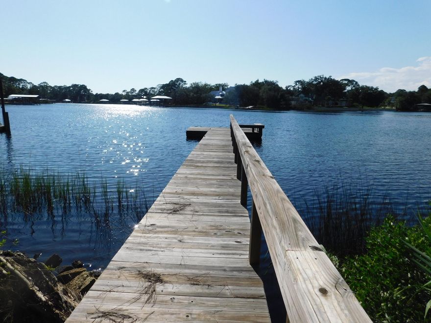 Beautiful deep water lot, 3/4 acre with mature oak trees and dock.  Price reflects lot with dock, utilities, and older Florida cottage for permanent or second home.  Plenty of room for guest house/garage/boat storage or house can be moved if buyer chooses new construction on this Waterfront lot.  Spectacular Sunsets, Dolphin watching, and Fishing and Crabbing from your dock. Custom made storm shutters.. Three bedrooms and three full baths with large bonus/living area or use as fouth bedroom on second floor, Direct-Vent Propane Fireplace for cool evenings, water views from living/dining area and kitchen.