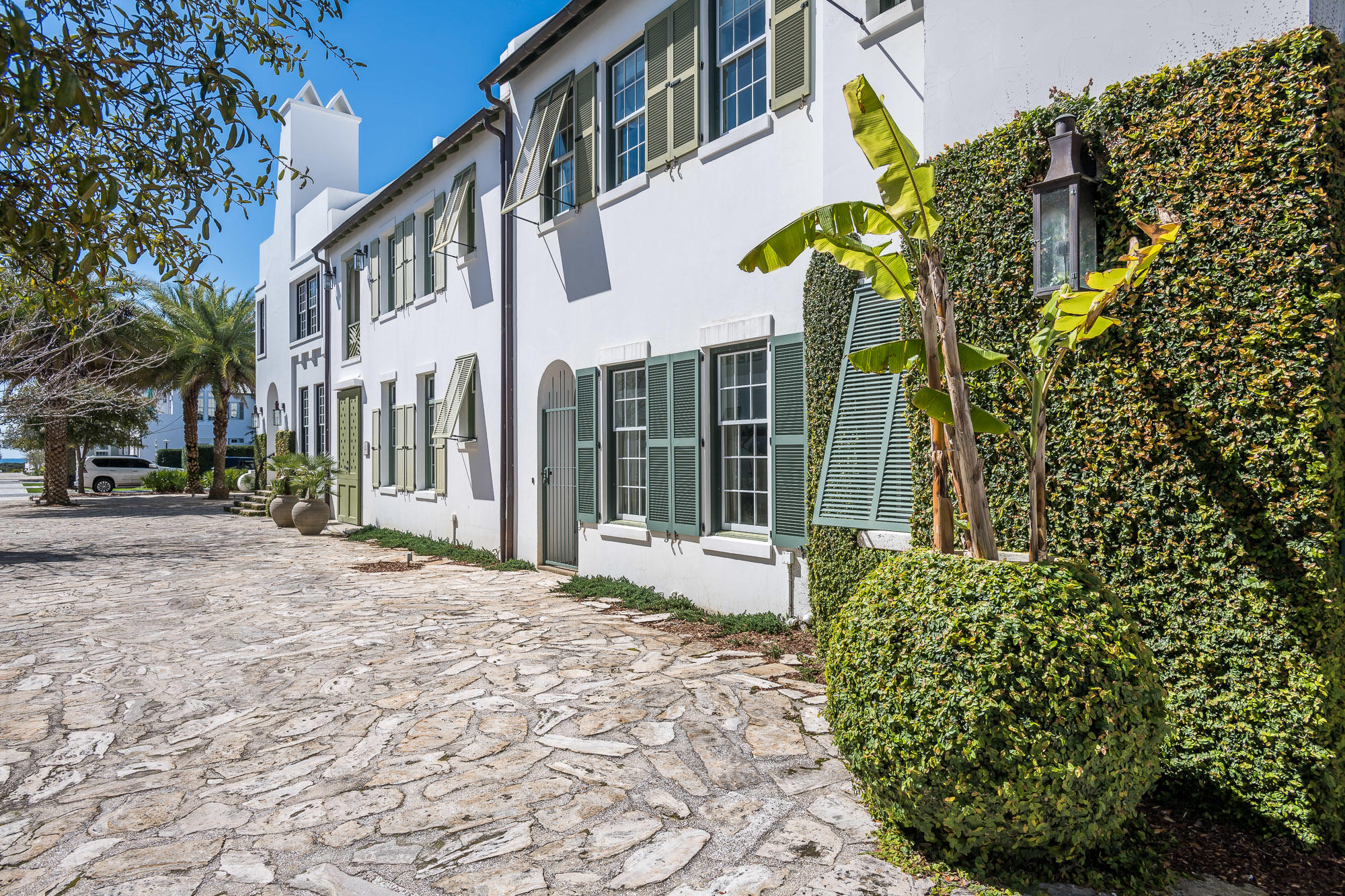 Designed by Steve Mouzon, this courtyard home has a sculptural chimney and fronts the pedestrian path that leads to the Gulf of Mexico. Tray ceilings extend to 15'8'' in the Living Room and Master Bedroom, both of which open onto a custom-designed, pavered courtyard planted with crossvine and Wahingtonian palm around a plunge pool. All interior walls are finished with Venetian plaster.