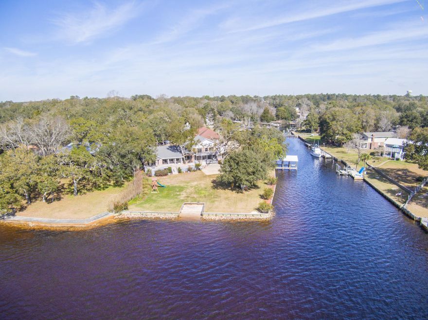 This waterfront lot cannot be beat with an optimum location and 300' of water front--100' on the bayou and 200' on the protected canal! This property is a rare find with the south side looking towards Destin and the east side surrounded by a quiet canal. The boat dock on the east side and the beach access to the south allow for all water activities! This is a prime property for swimming right off the backyard. The house sits on a cul-de-sac, perfect for kids! With 6 bedrooms and 4.5 baths, there is plenty of room for the whole family. Escape to the main-floor master off of the kitchen with large windows bringing in great natural light, the views of the bay are spectacular. The second master suite with a five piece bathroom has a balcony off the back overlooking the bay. An attached study with a wood burning fireplace makes for a private sanctuary. With two additional bedrooms upstairs, children are able to enjoy the bedroom with a loft.  Two additional bedrooms and a second office downstairs walk out onto the basketball court and expansive backyard. The kitchen is an entertainers dream equipped with Silestone Quartz countertops, stainless steel appliances, and ample cabinet storage. With panoramic views from the kitchen out onto the bay, you'll never want to leave! You don't want to miss this one of a kind property well maintained by the original owners.