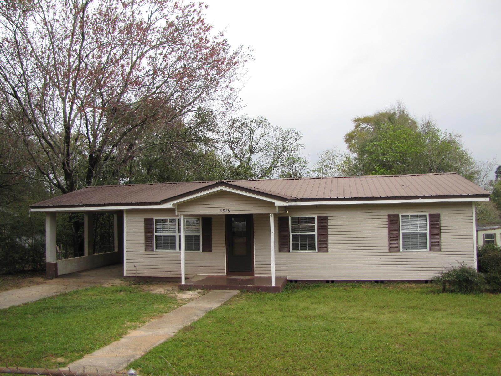 This would make a great starter home for a young family. The large eat-in kitchen has stove, refrigerator, and dishwasher. The home has original hard wood floors throughout and knotty pine paneling on the walls. There is a utility room in the carport for washer and dryer. The yard is entirely fenced. There is a storage building in the back yard.