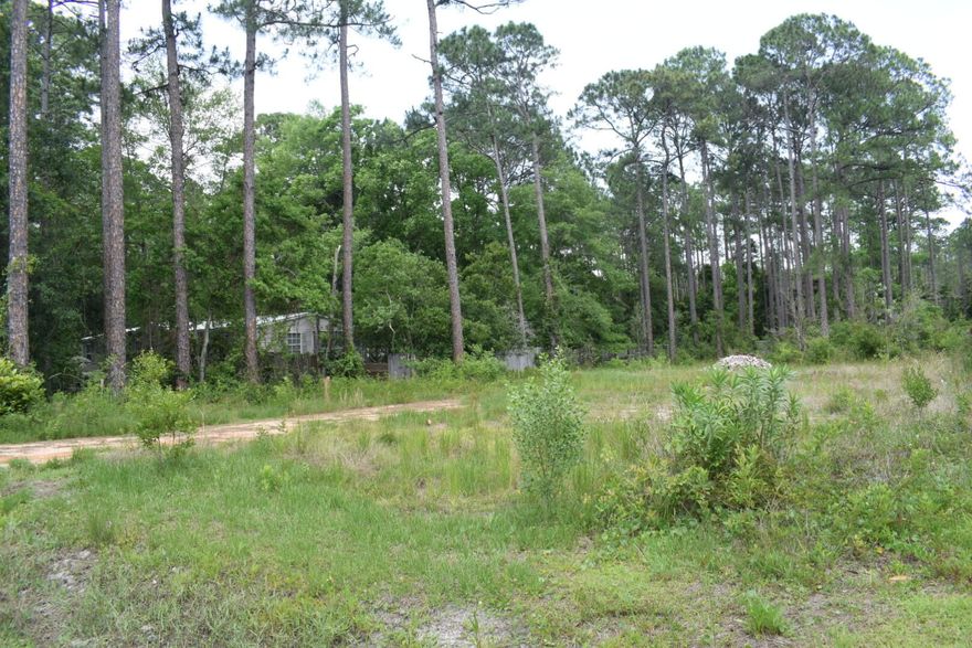 Over half acre of vacant  land with mature trees, lot is  partlly fenced, property is high and  dry with an elevation estimated at about 6 feet,  paved road  is directly in front of lot. Utilities are  available, electric, public water, sewer.   This  location is developing in a fast pace, making this property  a good investment  and a nice place to build a home. All information to be verified by buyer or buyer's agent if importante.