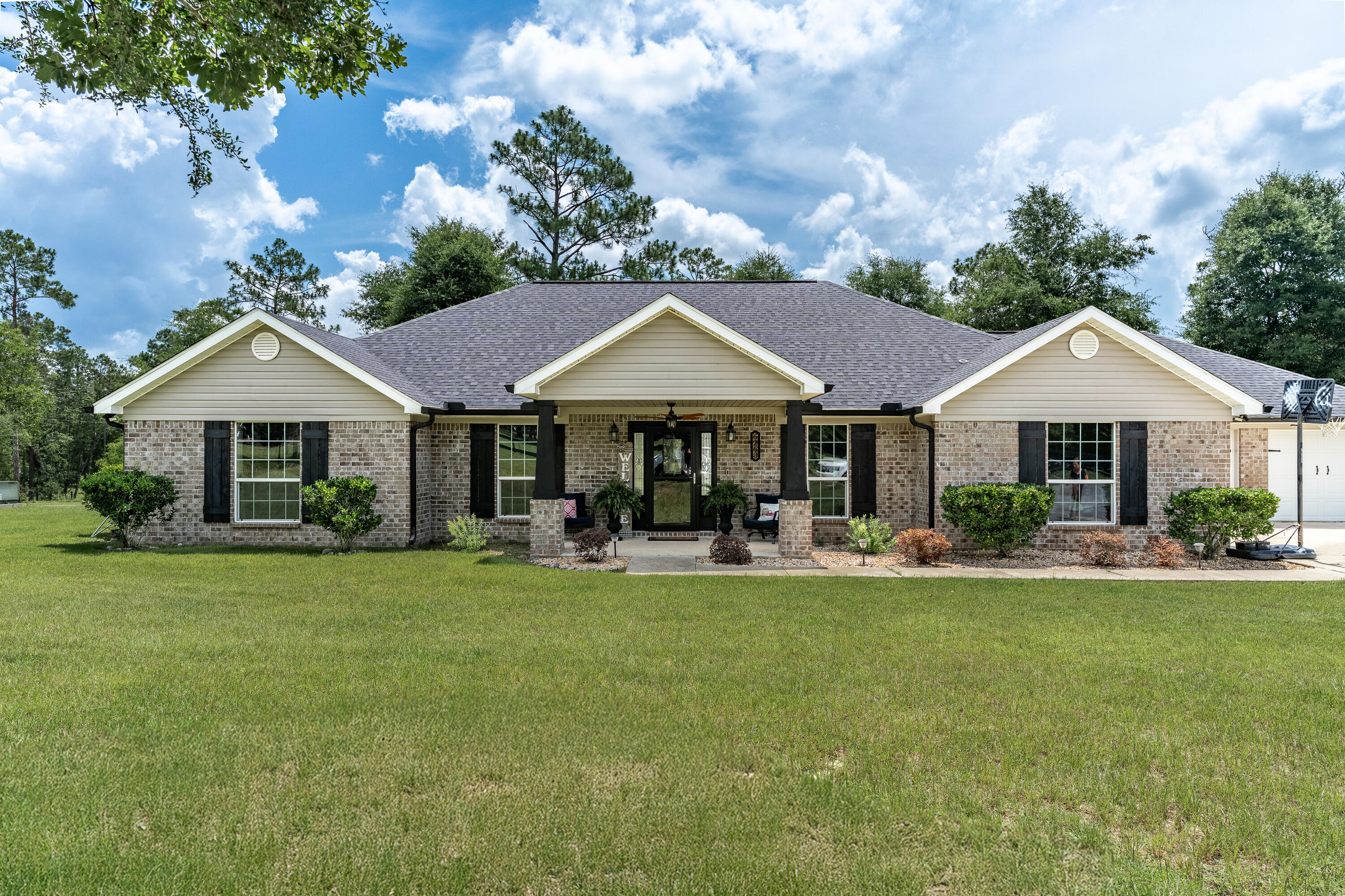 Discover the ultimate blend of serene country living and sophisticated comfort on this stunning 23.41 acre estate. This completely fenced-in property backs up to Yellow River Water Management for privacy. The focal point of the property is the gorgeous brick home. This immaculate home boasts LVP flooring, granite, gas fireplace and an open floor plan. Plenty of room for family and friends to gather while the breakfast bar seats 6 comfortably. The kitchen is designed with ample granite counter space, custom cabinetry and overlooks the family room. A split floor plan provides privacy for the entire family. A Generac whole house generator will provide you with peace of mind. The property has a 4 stall barn with concrete flooring and rooms for tack and fitness equipment. Two wells, one is 350' deep while the other is a spring well measuring 125'. They are tied together. A bubbling stream runs midway down the property. Diverse wildlife frequents the wooded back portion of property. Enjoy swimming in the heated salt water pool with hot tub which measures 14'x30'. An outdoor shower is in the pool area. There is so much to this amazing property that you will need to see it to believe it!!