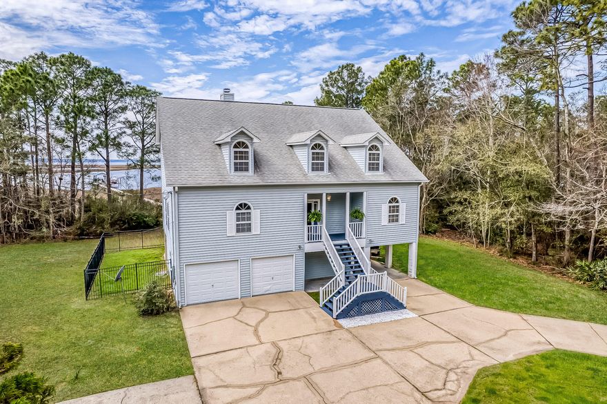 Move into instant equity with endless potential in this exceptional three-story waterfront retreat! This property is tucked away at the end of a quiet dead-end street for maximum privacy! Offering sweeping bay views from nearly every room, this 4-bedroom, 3.5-bath home is perfectly built for both tranquility and convenience. Highlights include a private pier, boat dock, a 32,000-lb boat lift, and a fully automatic dual jet ski lift - all while being just 5 miles from I-10 and 9 miles from Pensacola International Airport. The main level features an open and inviting living area with built-in shelving, a cozy fireplace, and new LVP flooring, all seamlessly connected to a screened-in covered patio equipped with no-see-um screens, ideal for enjoying waterfront breezes year-round. The spacious  kitchen provides abundant cabinetry and prep space, complemented by a formal dining room and a sun-filled breakfast nook. Just off the kitchen, a deck offers the perfect setting for outdoor dining with scenic bay views. The primary suite on the main level serves as a private retreat, featuring its own screened patio, a spa-like bathroom with a soaking tub, walk-in shower, dual vanities, a generous walk-in closet, and direct access to the laundry room. Upstairs, three additional bedrooms offer flexible living options, including a secondary suite with its own private bath and double closets, plus two additional bedrooms that share a full bathroom. The oversized two-car garage offers a workshop area, refinished floors, two storage closets, and washer/dryer hookups. Additional highlights include a fenced pet area with doggy-door access from the second floor and a covered two-car carport for extra parking. With easy access to Gulf Breeze and downtown Pensacola, this bayfront sanctuary is the perfect place to relax, entertain, and fully embrace life on the water!