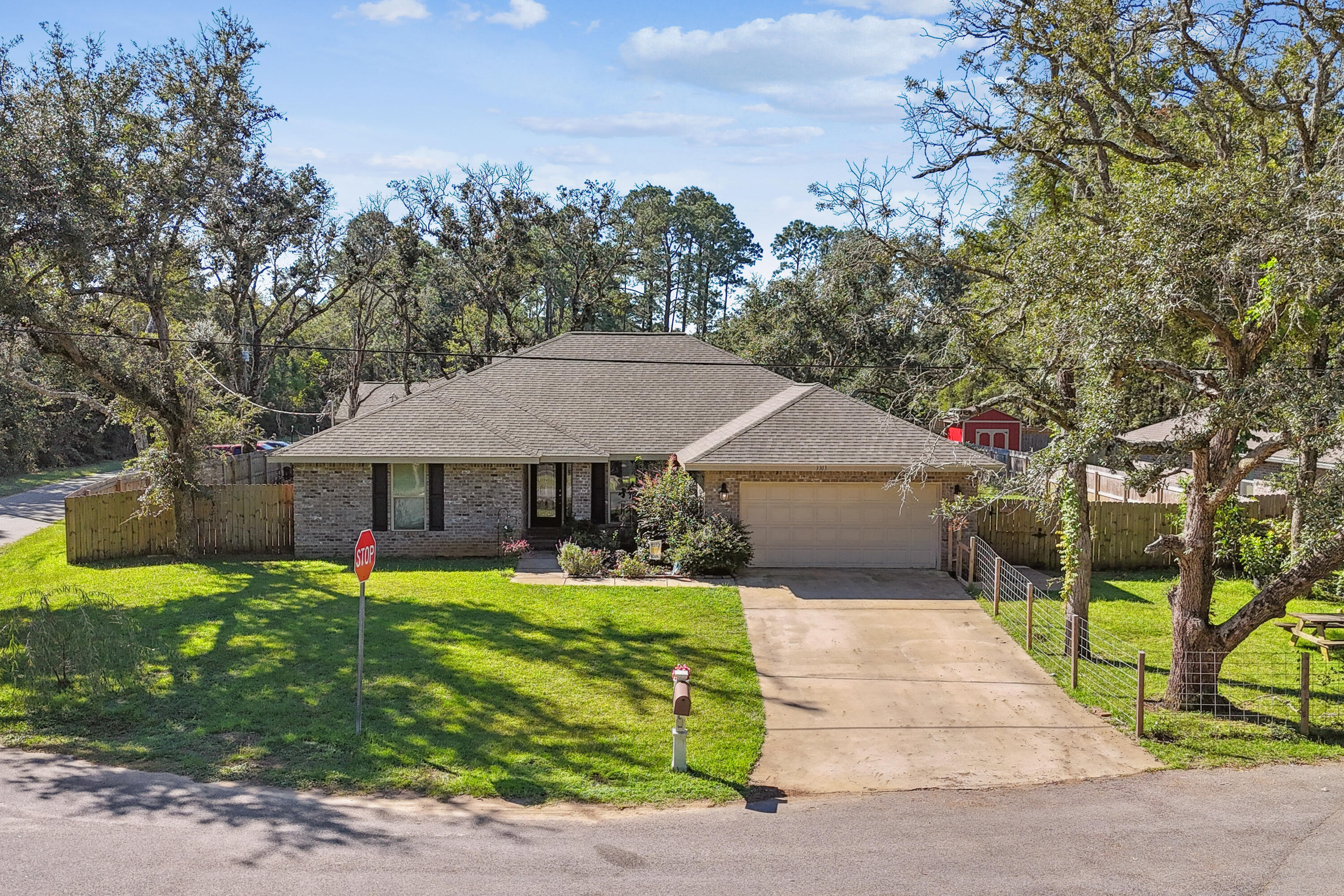 Discover the perfect blend of modern comfort and natural beauty in this 2,311 sq ft home, built in 2021. Featuring 4 spacious bedrooms, 3 well-appointed bathrooms, and custom details throughout, this home offers both style and functionality. Nestled on a generous 1/3-acre corner lot in a tranquil neighborhood just 10 minutes from the sugar-white sands of Navarre Beach, it's the ideal coastal retreat. The backyard is a nature lover's paradise, complete with lush new sod, eight thriving fruit trees--including mulberries, figs, and lemons--and a mature garden abundant with vegetables and greens. A full privacy fence creates a peaceful escape, perfect for relaxation and a haven for pets. The sprinkler system is powered by its own well, and the expansive yard provides endless possibilities for entertaining or customizing to your vision. The oversized 2-car garage adds extra storage space or room for a workshop, making it ideal for hobbyists or anyone with an active lifestyle. Inside, the open-concept kitchen is the heart of the home, boasting a large granite island, sleek stainless steel appliances, and convenient access to the stylish laundry room. The living room is designed for both entertaining and cozy evenings, with vaulted ceilings, a custom shiplap TV mantel, and an inviting electric fireplace. Modern smart home technology and energy-efficient windows enhance both convenience and sustainability. Built with quality and care, this home offers peace of mind and comfort for years to come. Experience the charm of country living while being just minutes from the coast, with easy commutes to military bases and local amenities. Don't miss your opportunity to view this stunning propertyschedule your showing today!