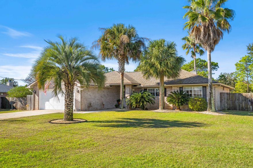 You won't want to miss this one of a kind 3 bed, 2 bath, brick home located in Holley by the Sea! Brand new roof installed in 2021 and a new water heater! Less than 10 minutes from the beach, this gorgeous home sits on almost a half acre showcasing towering palm trees, fenced backyard and lush grass. The kitchen features custom cabinetry, granite countertops, stainless steel appliances and an oversized island. With LVP flooring throughout, the open floor plan allows for a natural flow to the formal dining room and living room. The living room boasts vaulted ceilings, a gorgeous fireplace, and sliding glass doors leading to the expansive backyard. Natural light floods the main living spaces through the sizable windows and doors.