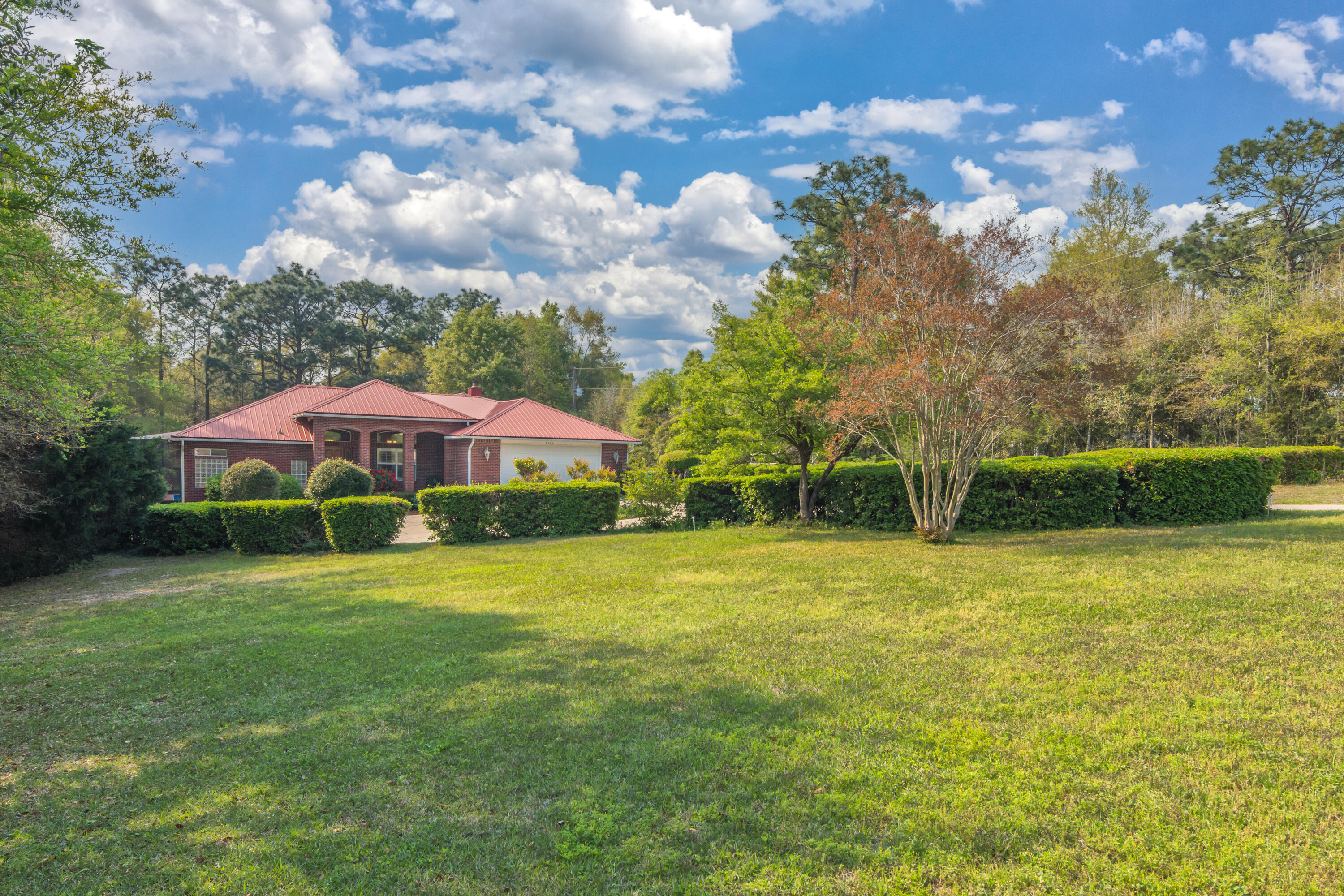 Finally!! A home unlike any other! This custom, open concept, split-floor plan home with a 40'x20' screened in pool and TWO 2-car garages on a huge 1.24 acre lot was built with every detail considered and made to entertain. Since 2012, the new owners have continued to update everything! New A/C in 2017. The kitchen received all new granite countertops, fixtures, and stainless steel appliances. The pool got a new liner, new pump, and a new screen for the enclosure. The floors were all replaced with gorgeous marble tile and wood throughout. Each of the three bathrooms has been updated and upgraded. Beautiful plantations shutters have been installed on each of the many windows. New paint and fixtures throughout. The generous 1.24 acre lot stretches from Wildwood to Tallokas Rd. The Wildwood entrance features a circle driveway with a two-car garage and the Tallokas entrance features a SECOND 2-car garage! The second garage is oversized with room for a workshop, fully insulated, and has duct work in place for a permanent enclosure. Make your own man-cave, exercise room, home office, or teen game room! This home was made to entertain with plenty of space for guests to spread out and enjoy time together. With a beautiful view of the pool and the private wooded lot, the cathedral ceiling living room is an ideal place to gather. Then, move past the dining space into the kitchen with bar stool seating that opens up to the family room. You'll be amazed by the craftsman 25'x25' cypress tongue and groove ceiling with recessed lighting and a large brick fireplace. Directly off the kitchen, access the outside living space featuring a long porch (with endless storage underneath to hide all the pool toys) and steps leading down to the pool deck. Plenty of space for all your grilling needs and room to relax around the pool. And speaking of the pool! This is a BIG pool and plenty deep to dive and have all the fun you want! There's even an outdoor shower with cold and hot water. The enormous master suite also has its own access to the pool and boasts a huge walk-in closet with 12' high ceilings for extra storage. The master ensuite is like no other! An extra long double-sink features storage above and below. The whirlpool spa tub and custom make-up counter are any woman's dream escape. Not to mention the large walk-in shower complete with a bench and custom towel storage. The guest bedrooms are located past the kitchen and down the breezeway that overlooks the pool with floor to ceiling windows. One guest bedroom is a spacious 15'x15' and boasts its own ensuite that was just remodeled this year with a frameless walk-in shower. The other bedroom has it's own bathroom as well across the hall. Down the breezeway you'll also find a large office nook, laundry, and access to the second garage. Outside the pool oasis, the 1.24 acre property boasts a large front yard, vegetable garden area, and an extensive variety of plants, shrubs, and trees for plenty of privacy. There is a sprinkler system throughout the yard and garden. And as a bonus, all the TVs will convey with the house! This place will truly take your breath away--come see it before it's gone!