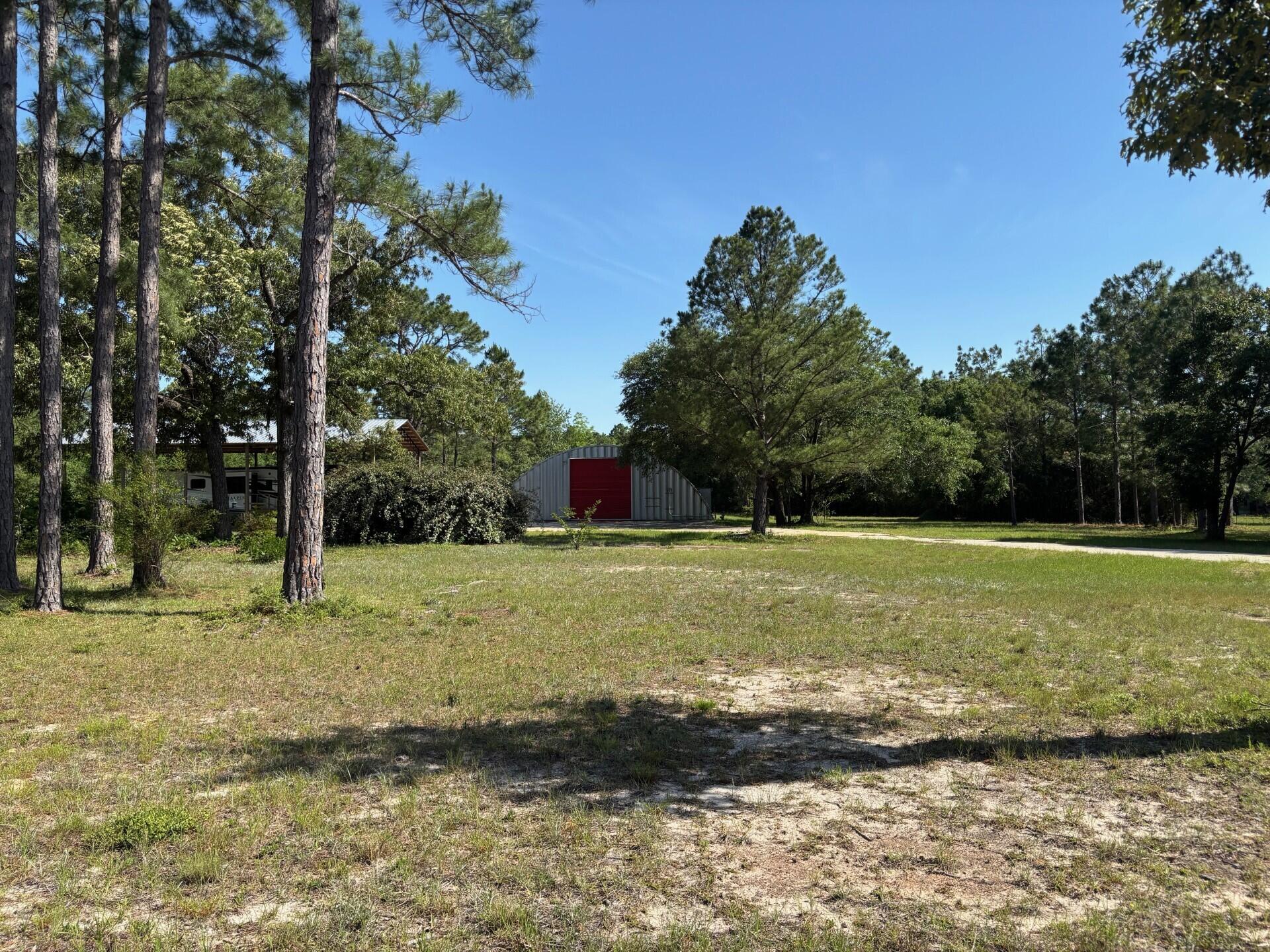 Don't miss this incredible opportunity to own approximately 4.47 acres just outside of Crestview, located in one of the area's fastest-growing corridors. Enter thru new electronic gates to see 5,000 sq. ft. Quonset hut built on a robust 15-inch concrete slab, complete with a loading dock, full utility access and a sprinkler system on top to keep the building cool. This expansive structure is ideal for storing RVs, boats, building materials, or operating a variety of commercial ventures.Additional features include:New Pole Barn for 45' RV; Two city water meters; Deep water well; Two like-new septic tanks; Three full RV hookups with 30AMP service & 50AMP. InternetWhether you're looking for space to build, grow, store, or invest, this property delivers unmatched potential.