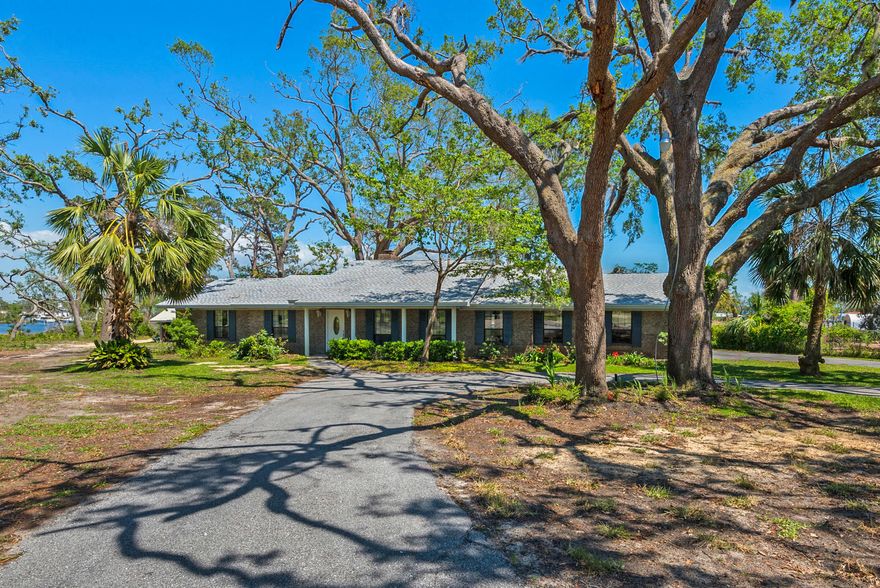 Beautiful all brick waterfront home! All furnishings and appliances included! In-ground pool! Seller is allowing 10k for any painting or upgrades! New Roof in March of 2019! This home is on almost an acre lot with the entire back of the property situated on the Bayou with a private 90' boat dock, 28x16 boat shed and workshop with electricity and a new aluminum shed.Lawn irrigation system has been recently serviced !This home is in excellent condition and has been very well taken care of by the original owner since 1982.A must see property if you like waterfront living and a feeling of privacy and serenity,being only minutes from shopping, dining and the Gulf's beautiful beaches! Check out the pictures and come see this home for yourself. call and make an appt for your private showing!