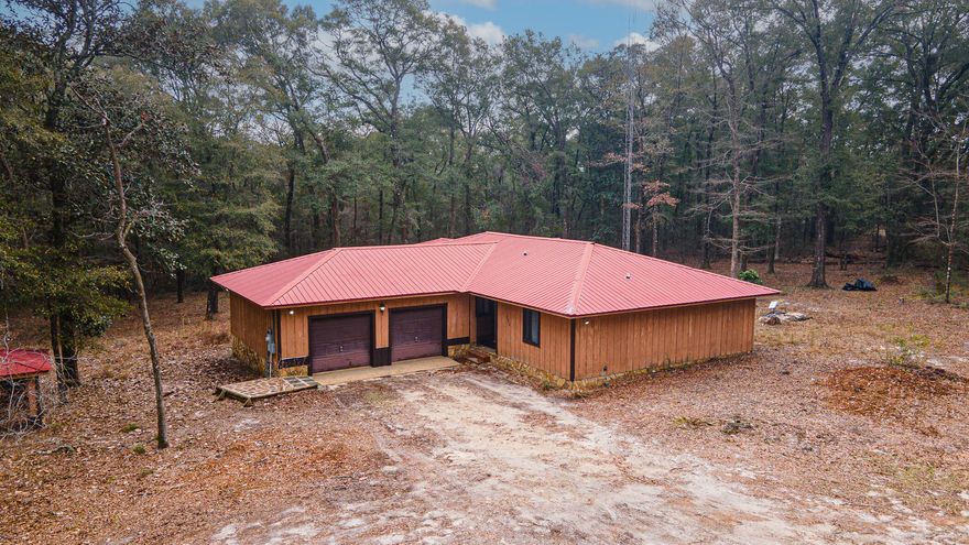 You found your retreat in North Walton County. Amazing 9.95 acres of tranquility and nature's beauty. Enjoy exploring the open doors, canopy of mature trees and a natural creek that runs on the back part of the property. You will enjoy the delicious fruit trees on the property as well, from lemon, peach, kumquat, and blueberries. All of this plus a move in ready house with a metal roof and new floors. The home is freshly painted and has 3 bedrooms, 2 bathrooms with a 2-car garage. It also includes an additional bonus detached 2-car garage, previously used as a workshop. Located just 45 minutes from the gorgeous sugar white sand beaches of Walton County. Don't miss this rare find in DeFuniak Springs. Call now to schedule your showing today!