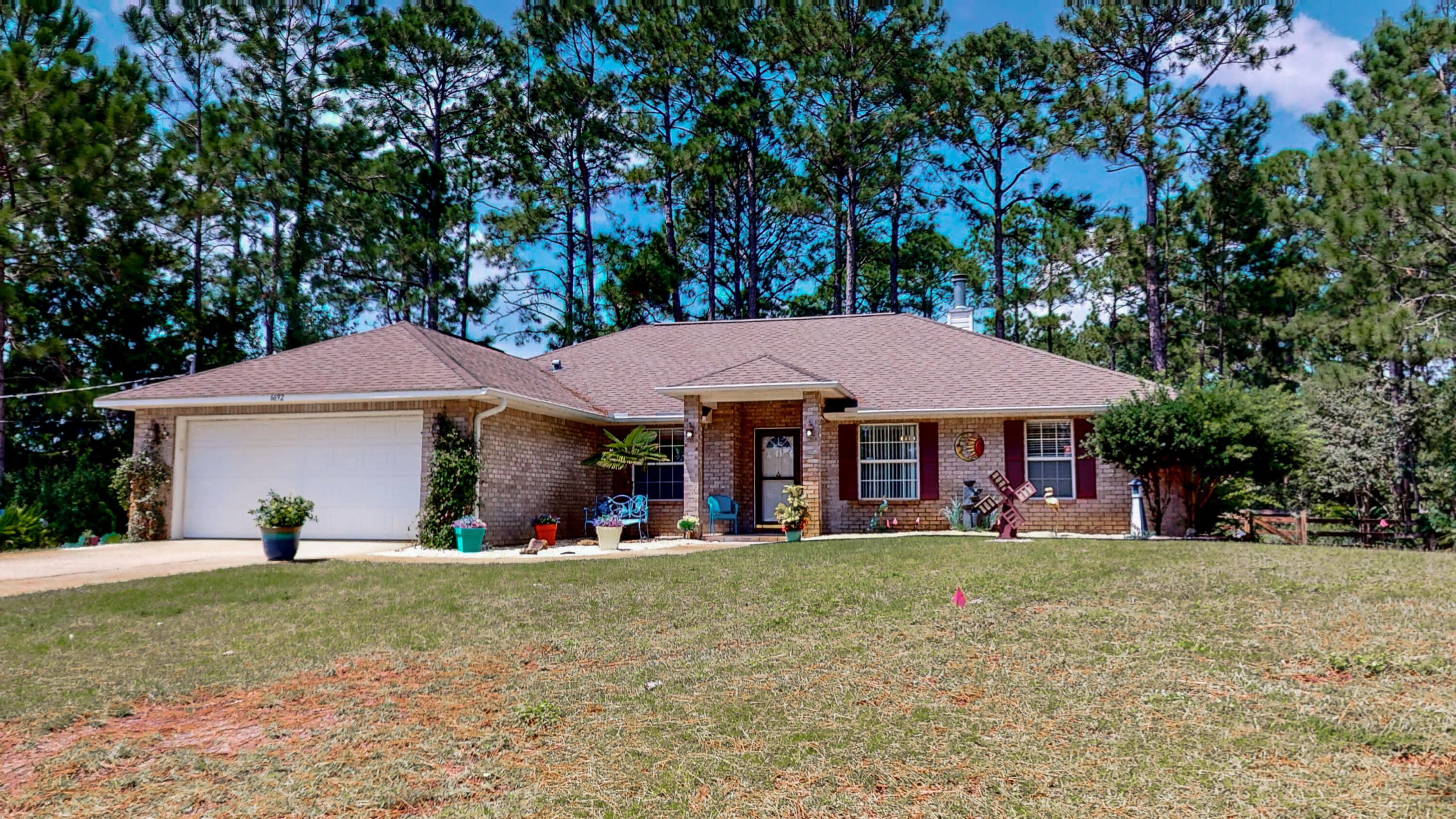 This lovely brick custom home spans 2 lots with mature trees and lush fragrant plants that offer placid privacy. A covered porch welcomes you through the door into a large, sunny living room. You'll love the premium luxury vinyl floor, cathedral ceiling, plant shelves, and wood-burning fireplace. The kitchen has oak cabinetry, a big pantry, and new stainless steel appliances. Two bedrooms are behind a sliding French door, plus a tiled full guest bath. The master bedroom and en suite are on the other side of the home, with a huge closet and large walk-in shower. The 4th bedroom was an office, so there are additional power outlets in the closet. Out back, the massive Florida room is perfect for entertaining and the new saltwater hot tub conveys. Water heater and HVAC both new in 2019.