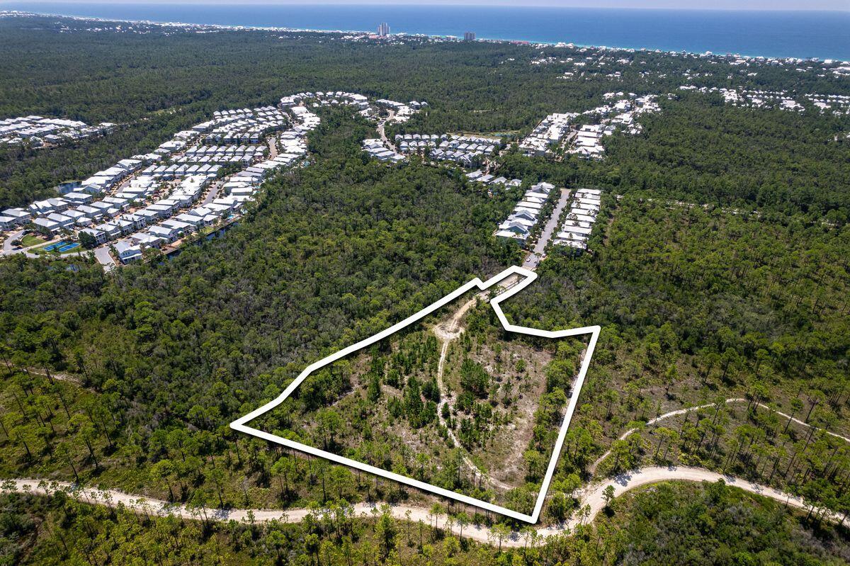 Presenting a remarkable opportunity within the esteemed NatureWalk Community Development District, this 3.2-acre parcel of land unveils a world of potential. While distinct from the NatureWalk HOA, this developable expanse bears its own exceptional character. Conveying with a collection of 24 townhome units in a pre-approved development order, it stands poised to grace Walton County with an embodiment of sophisticated living. The piece de resistance of this community will be the splendid neighborhood pool, a captivating focal point that will elevate the living experience. Each townhome unit will boast a view that encapsulates the allure of Point Washington State Forest or the tranquil embrace of the pond and pool.. With the notion of opulent living in mind, the floor plans unveil an intuitive arrangement. The primary living spaces flourish on the first floor, designed to cater to modern sensibilities. Transitioning to the second floor introduces a haven of luxury, featuring three bedrooms, two baths and a versatile bonus room. Elegance is intertwined with convenience. A full side-by-side laundry, along with a discreet powder bath on the first floor, attests to the thoughtful craftsmanship that defines these homes. Each dwelling is a testament to tasteful design, spanning two stories and embracing 1,750 square feet of refined living. Furthermore, discerning homeowners have the option to transcend the ordinary. The possibility of an additional third story awaits, allowing for an expansion of 550 square feet per townhome. This can bring the total square footage to 2300 square feet.  Beargrass Way, the premiere street within NatureWalk, cradles this distinguished development. With its coveted position near the front of the community, seamless accessibility to WaterColor and Seaside, Florida, is a given, whether by golf cart or leisurely bike ride. Overall, this opportunity is a testament to sophisticated living, where architectural brilliance converges with the tranquility of nature. Engineering site plan, townhome floor plans and Letter of Agreement with the Naturewalk CDD are uploaded into the Documents section of this listing..