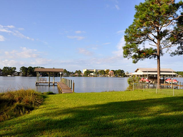 BACK ON MARKET!! RARE NORTH LAGOON CONTEMPORARY WATERFRONT HOME. This beautiful home has 95 ft of waterfront on the widest end of the Grand Lagoon and is only 1/4 mile west of Captain Anderson's Marina. It has a small, sandy beach area for the kids or to beach your jet ski. A beautiful paver stone walkway leads to a covered boat dock with lift, electricity, and water. A newly added spacious and covered patio is there to enjoy the spectacular sunsets and the soothing sounds from the included water fountain. This home was recently upgraded with granite counter tops in the kitchen, rich solid wood cabinets, stainless Kitchen-Aid appliances, and a Florida room showcasing wall-to-wall windows and beautiful wooden plank ceiling treatment.