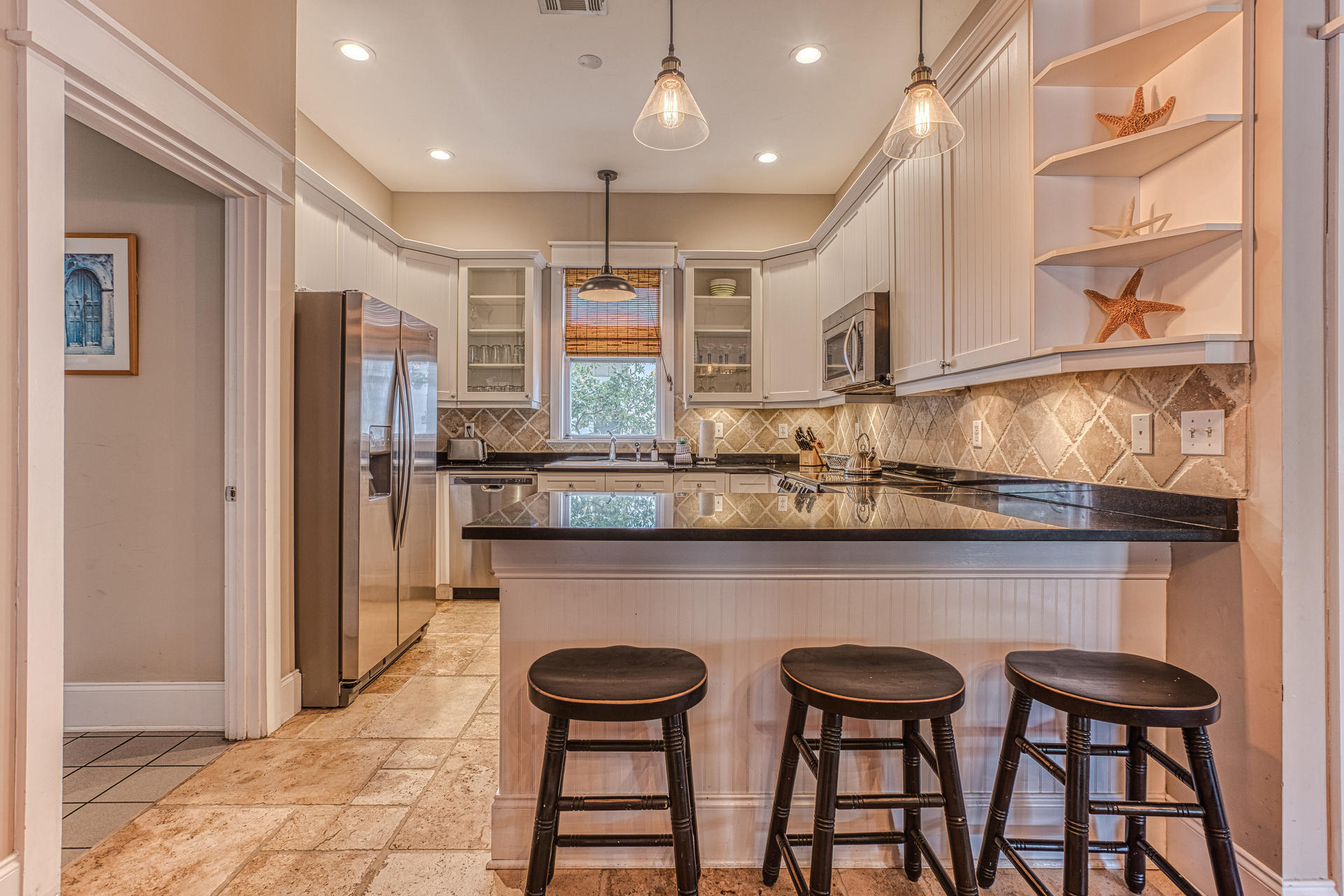 This exquisite one-story home, known as ''Down on the Corner,'' lives LARGE with a spacious open floor plan, hardwoods throughout, a charming wraparound porch, corner lot, and a 12,000 sq. ft. community lagoon pool. Sold furnished, walk through the front door and be greeted with a comfortable living area, complemented with vaulted ceilings. The dining and kitchen area sits perfectly for entertaining family and guests. The spacious master bedroom sits just off the dining room along with a large master bathroom with a jetted tub, standup shower and double vanities. The 2 additional bedrooms sleep many, with one being a double bunk room and the other a large bedroom. Relax with family and friends in deep porch shade while you cook dinner in the outdoor grilling area.