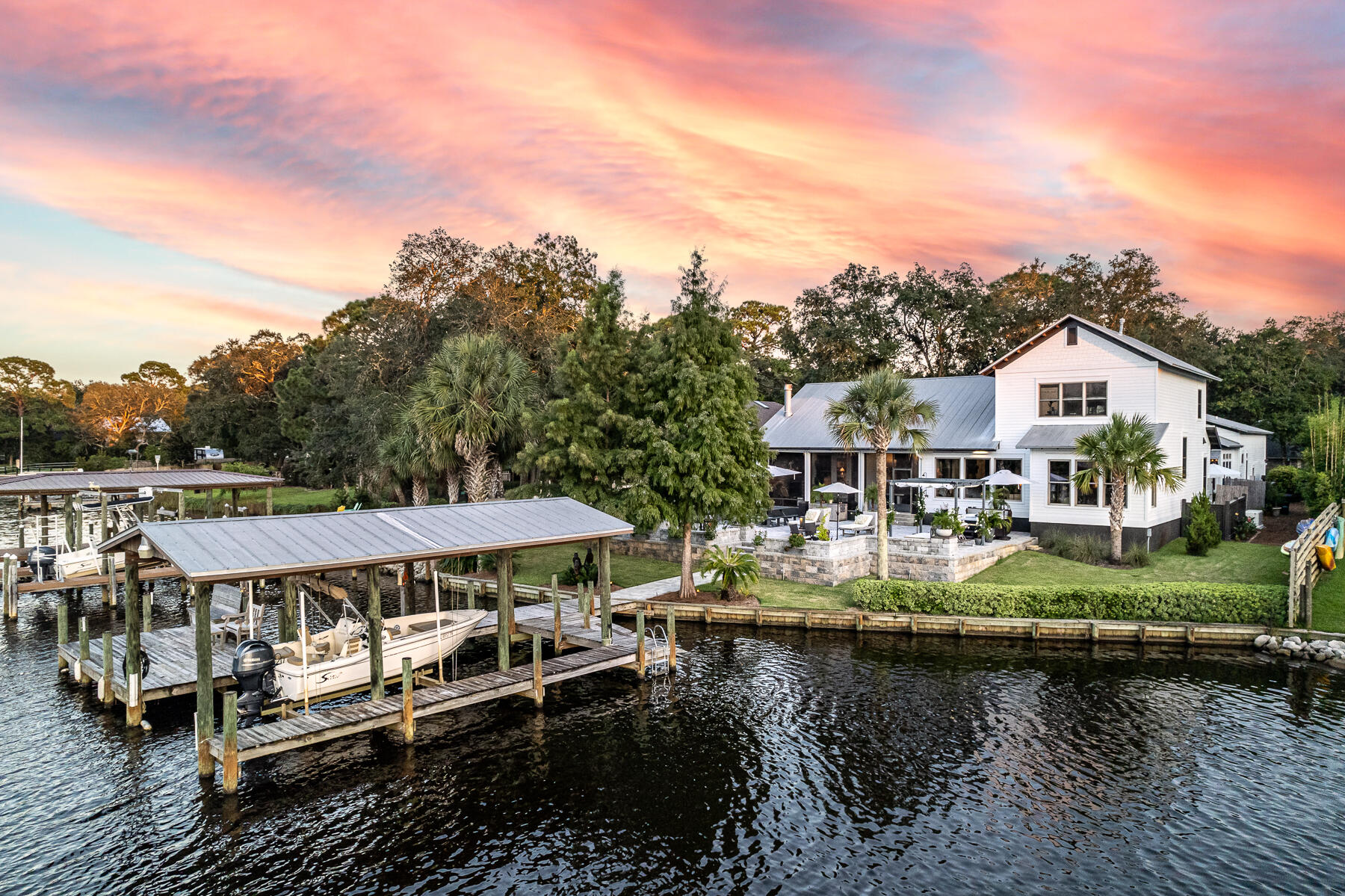 Love boating and entertaining, then this house is for you! Spectacular waterfront home on deep water Buck Bayou, featuring 91 ft of waterfront living with a dock and new lift. This private, gated retreat is tucked away amongst the carefully curated landscaping of the front and yard which is just a taste of what the indoor and outdoor living spaces have to offer. Windows adorn the entire back of the main home on the first floor showcasing the water views throughout. The first floor of this open concept home features the primary suite, powder room, dining room, living room, kitchen and office. Nearby, but tucked away, is a butler's pantry featuring a bar, beverage refrigerator, warming drawer, storage, sink and washer and dryer. The upstairs includes two bedrooms each with their own bathroom