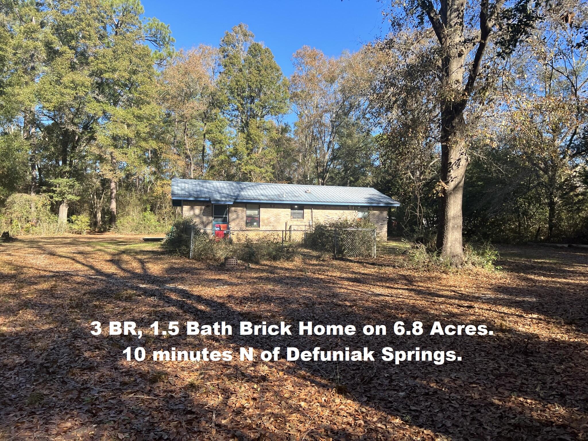 Cozy 3 BR, 1.5 bth brick home, set back nicely from the road & nestled among apx. 6.8 ac of woods. Lot is apx. 173' at the road, 208 at the back & apx. 1336' deep (see aerial in photos). The perimeter has been fenced but may need repairs. A large portion of the land was previously pastureland & could be cleared again for horses, other livestock, chickens. There is a small pole barn that could be used for tractor, carport, shelter for livestock. The brick home is on a slab & in good condition. Metal roof installed apx. '02. HVAC is older but currently no issues. Interior of home is good but would need some updating & new flooring (due to flooring, NO FHA or VA) . At this affordable price, & with a little TLC, you could have your diamond in the rough & make this your perfect little paradise.