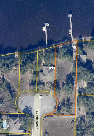 WELCOME to your future home in the much sought after community known as Grand Bay Estates. This 33-lot subdivision in Navarre off East Bay Blvd is close to area shopping, dining and entertainment. This LARGE, BEAUTIFUL lot in Grand Bay Estates is ready for your CUSTOM built DREAM home. It is a HIDDEN, WATERFRONT GEM and, is NOT in a flood zone! It is over 1/2 an acre and boasts nearly 100' of MAGNIFICENT WATERFRONT VIEWS of the East Bay with a community pier and MATURE trees! THIS LOT IS STUNNING!! Underground utilities, paved sidewalks, public dock access as well as public water and sewer make this lot an incredible opportunity not to be missed. Don't forget to check out the video of this awesome lot. Survey and soil study available upon request.