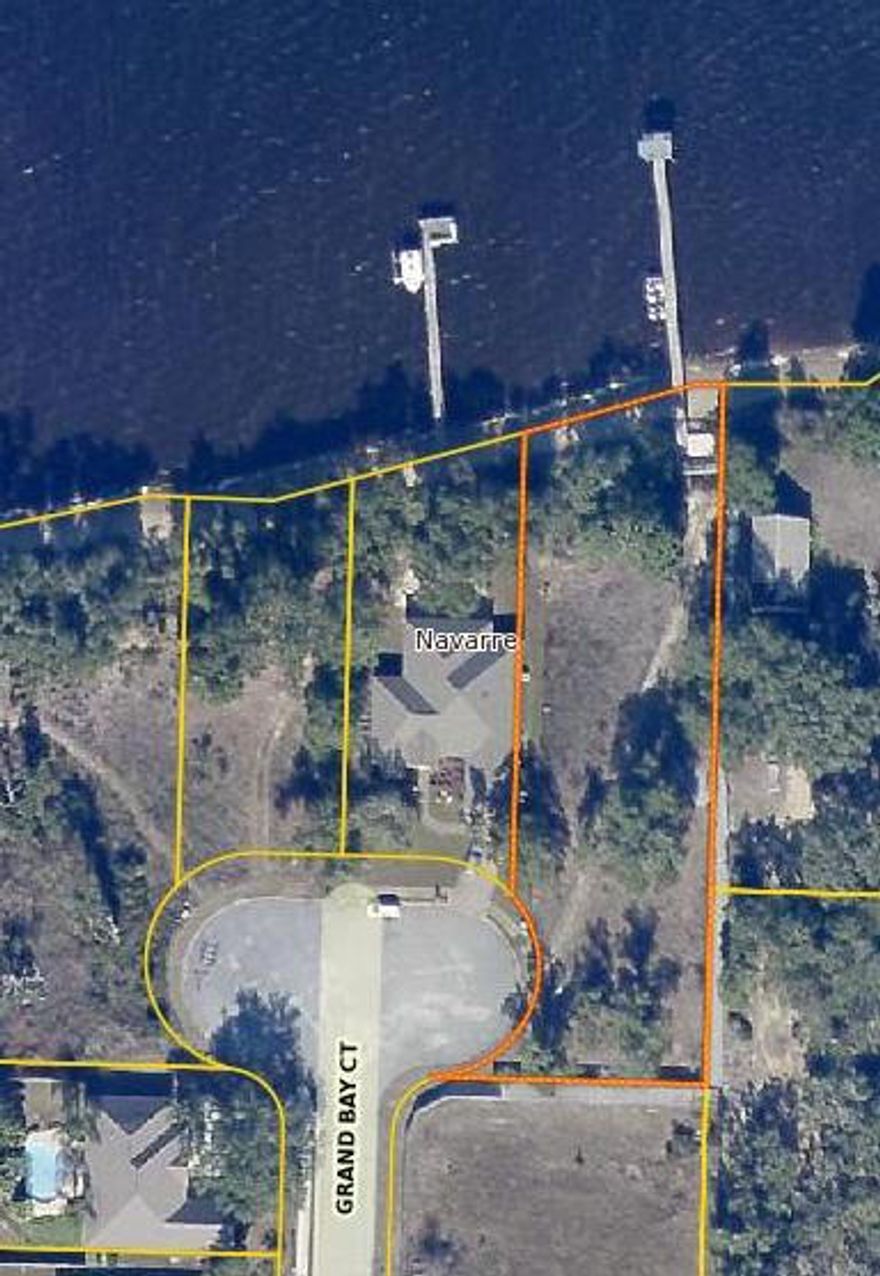WELCOME to your future home in the much sought after community known as Grand Bay Estates. This 33-lot subdivision in Navarre off East Bay Blvd is close to area shopping, dining and entertainment. This LARGE, BEAUTIFUL lot in Grand Bay Estates is ready for your CUSTOM built DREAM home. It is a HIDDEN, WATERFRONT GEM and, is NOT in a flood zone! It is over 1/2 an acre and boasts nearly 100' of MAGNIFICENT WATERFRONT VIEWS of the East Bay with a community pier and MATURE trees! THIS LOT IS STUNNING!! Underground utilities, paved sidewalks, public dock access as well as public water and sewer make this lot an incredible opportunity not to be missed. Don't forget to check out the video of this awesome lot. Survey and soil study available upon request. There is an easement that goes along the outside of the fence for owners to use to access the community dock.  Listing Agent has obtained all information from County Records and Sellers Disclosures; although information provided is deemed accurate, the Buyer and/or Buyer's Agent should verify all details pertaining to this property, including but not limited to parcel dimensions, school zoning, zoning classifications, land use and any and all other information that may affect the Buyer's purchase of property.